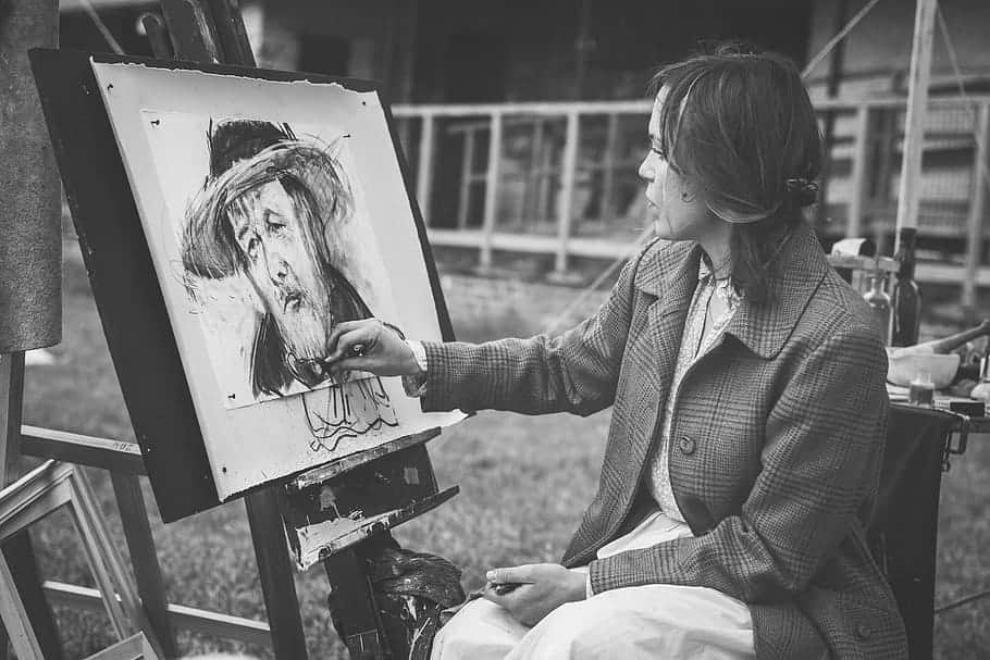 Charcoal Drawings 桌布 壁紙 — 一位身穿格紋外套的女士在戶外畫架上用黑白素描一幅肖像。