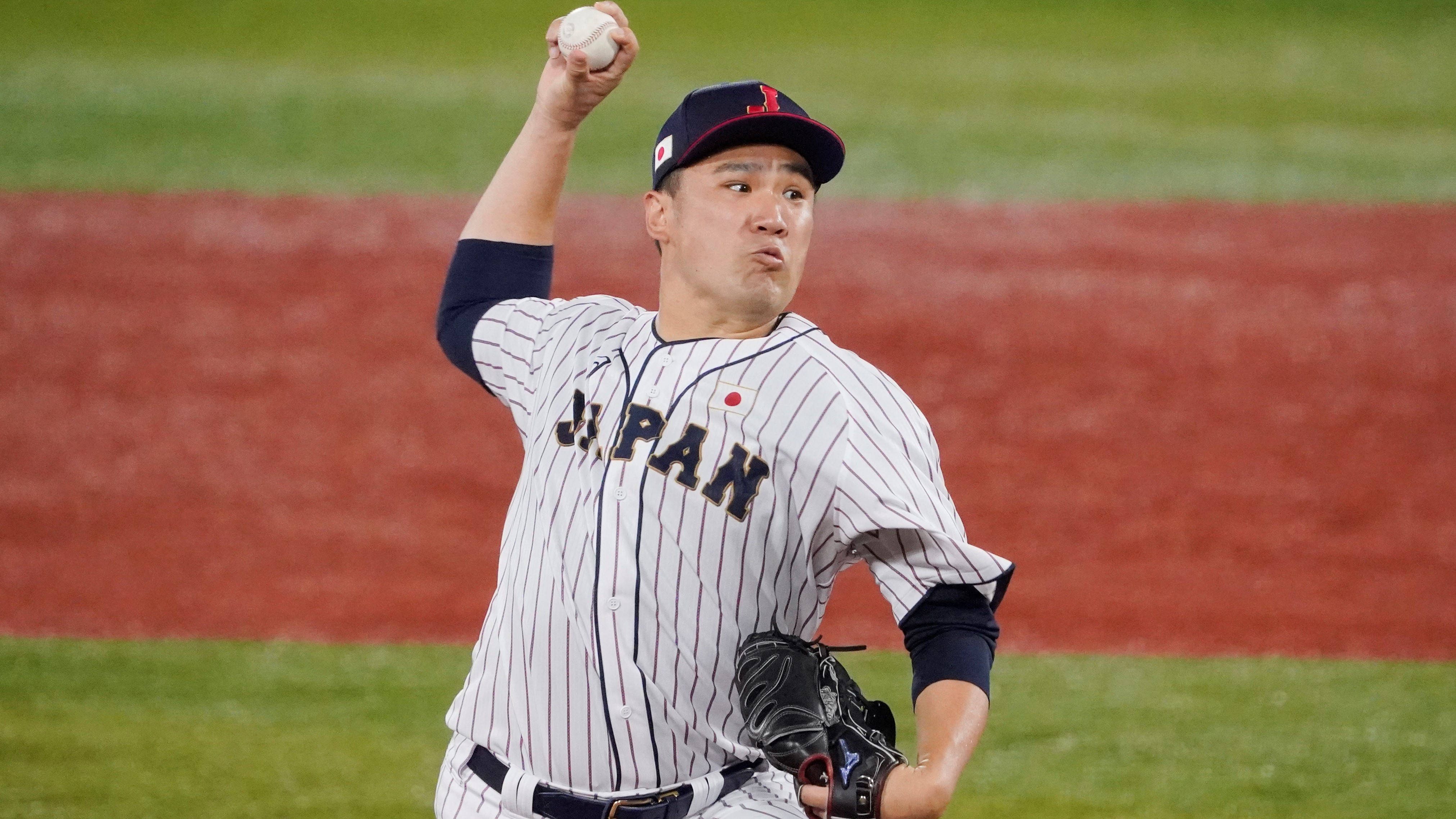 masahiro tanaka 桌布 壁紙 — 一位身穿條紋球衣的日本棒球投手在夜間光線充足的球場上準備投球。