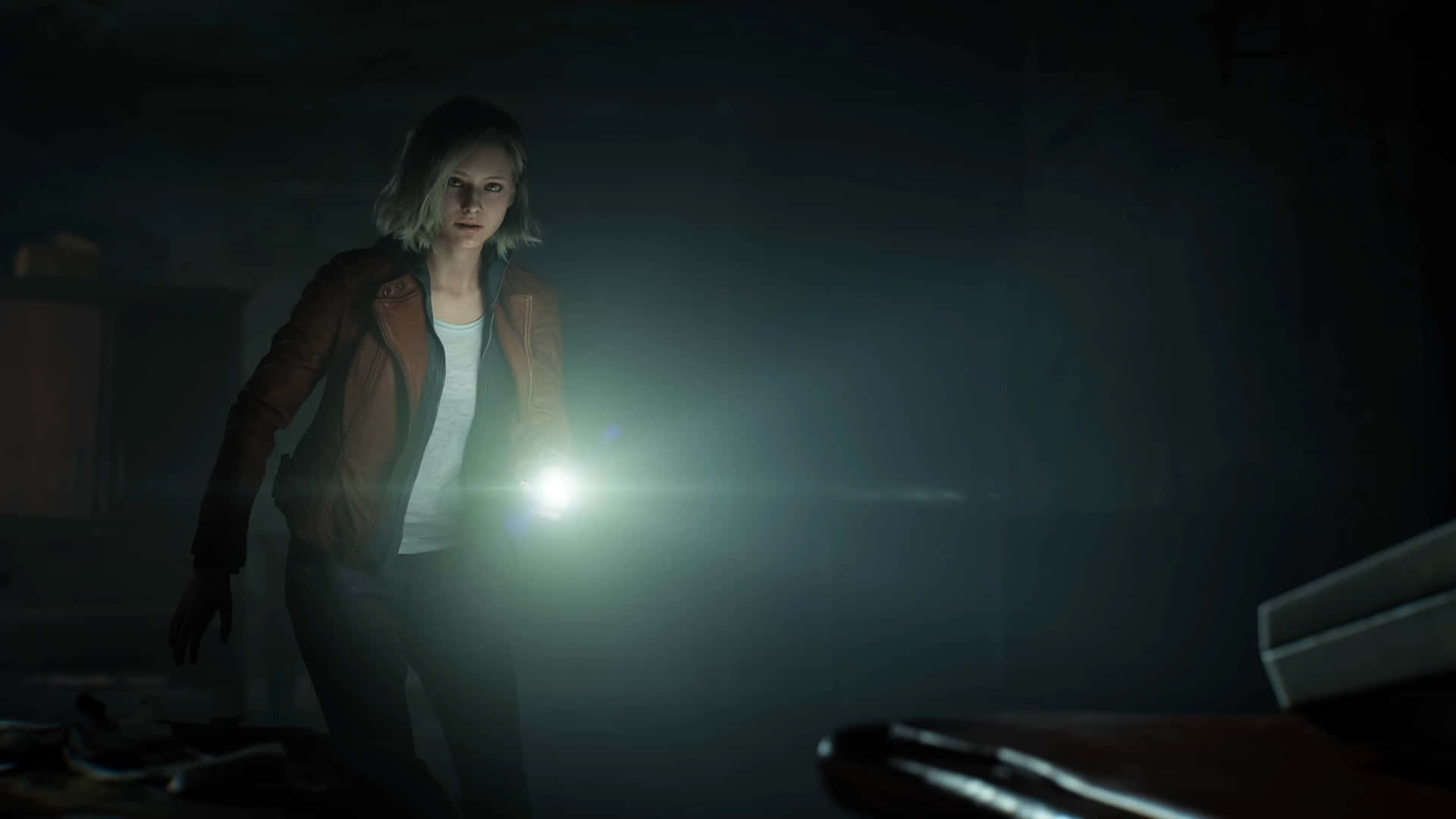 Resident Evil Requiem Grace Ashcroft 壁紙 — 一位身穿棕色外套的女性手持手電筒，照亮一個佈滿灰塵家具的黑暗廢棄房間。
