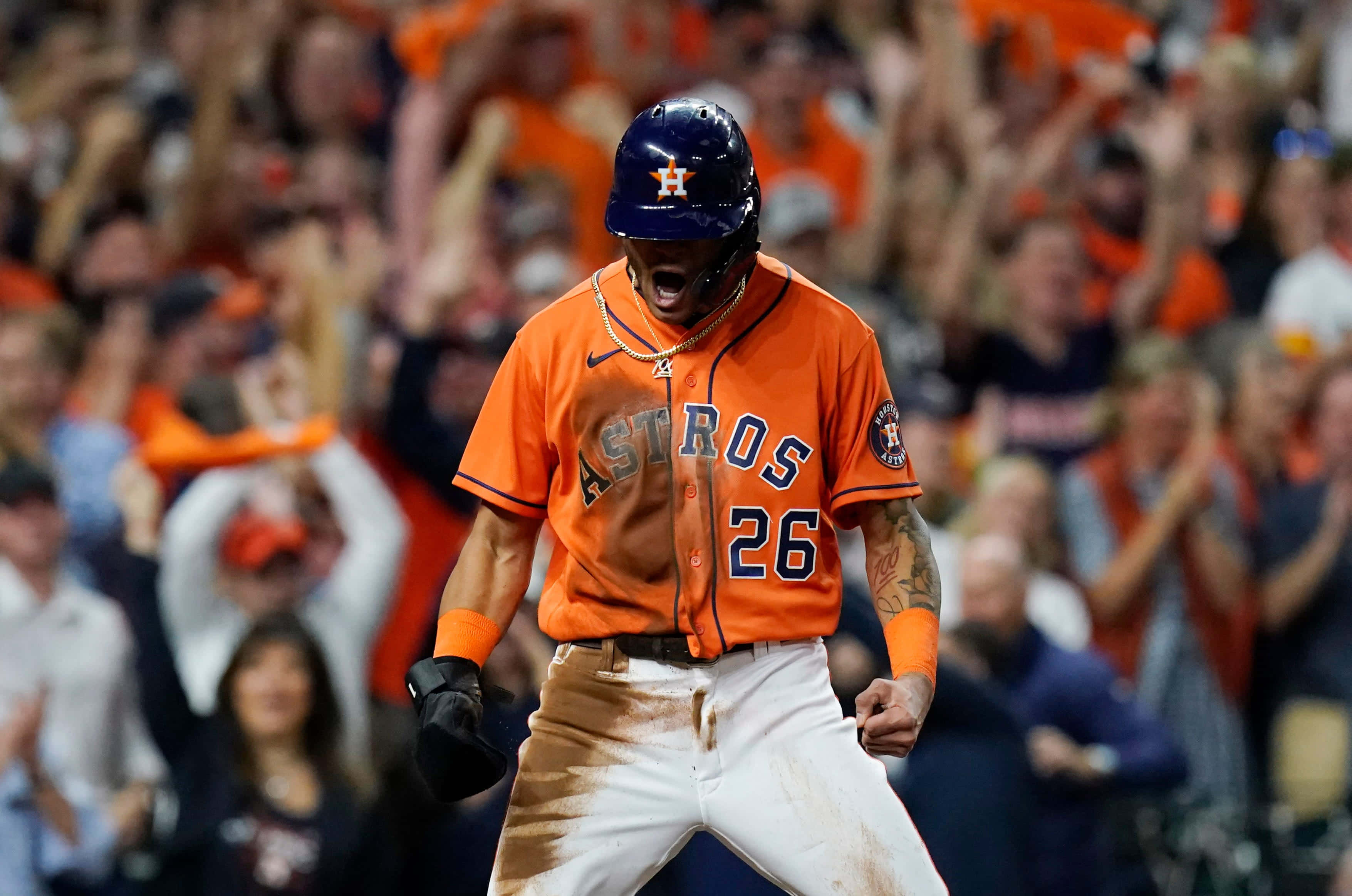 Astros 桌布 壁紙 — 一位身穿橙色26號球衣的休士頓太空人棒球選手，褲子沾滿泥土，在身後歡呼的人群中發出勝利的怒吼。