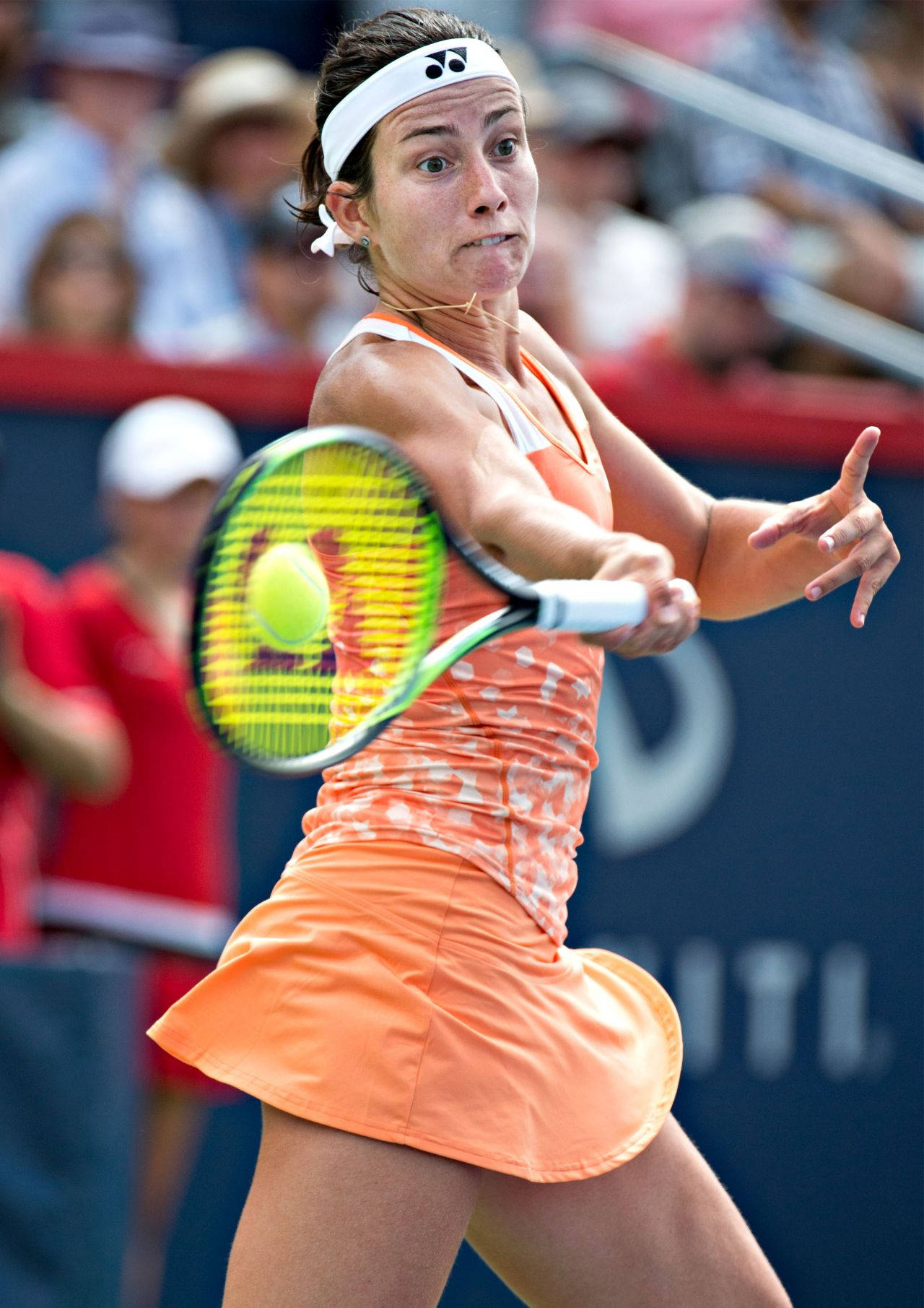 Tennis 桌布 壁紙 — 一位身穿橙色服裝的女網球選手在比賽中揮動球拍擊打亮黃色的球。