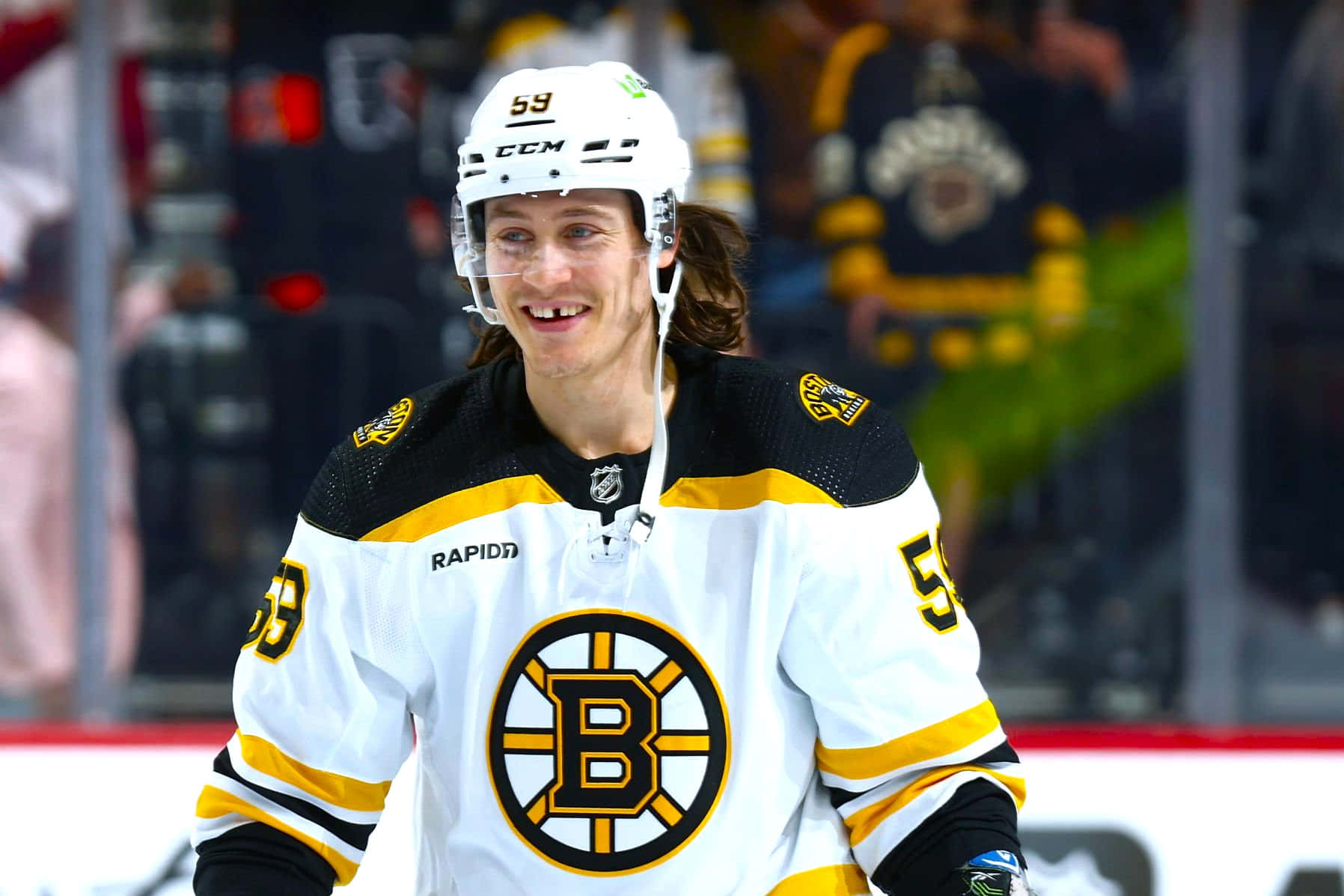 Tyler Bertuzzi 桌布 壁紙 — 一位身穿波士頓棕熊隊59號球衣的冰球運動員在冰上比賽中笑容滿面。