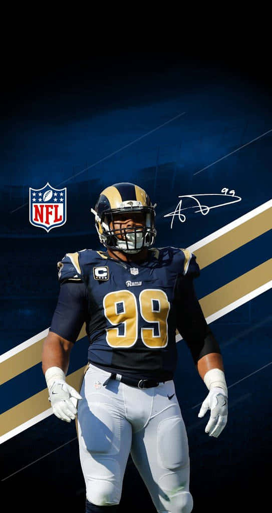 Rams 桌布 壁紙 — 一位身穿海軍藍和金色球衣的洛杉磯公羊隊NFL美式足球員，背號99，自信地站在黑暗的球場背景下。