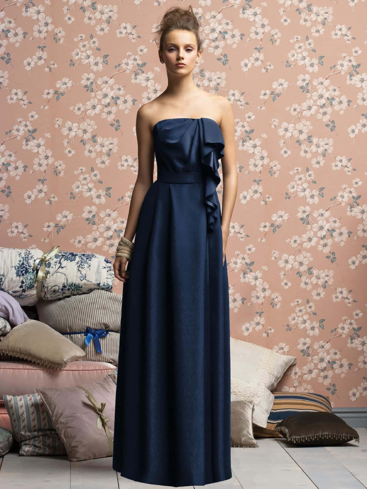 Navy Blue Dress 桌布 壁紙 — 一位身穿海軍藍無肩帶連衣裙的女性，在粉紅色花卉壁紙背景前，伴隨著一堆舒適的圖案靠墊，優雅地擺出姿勢。