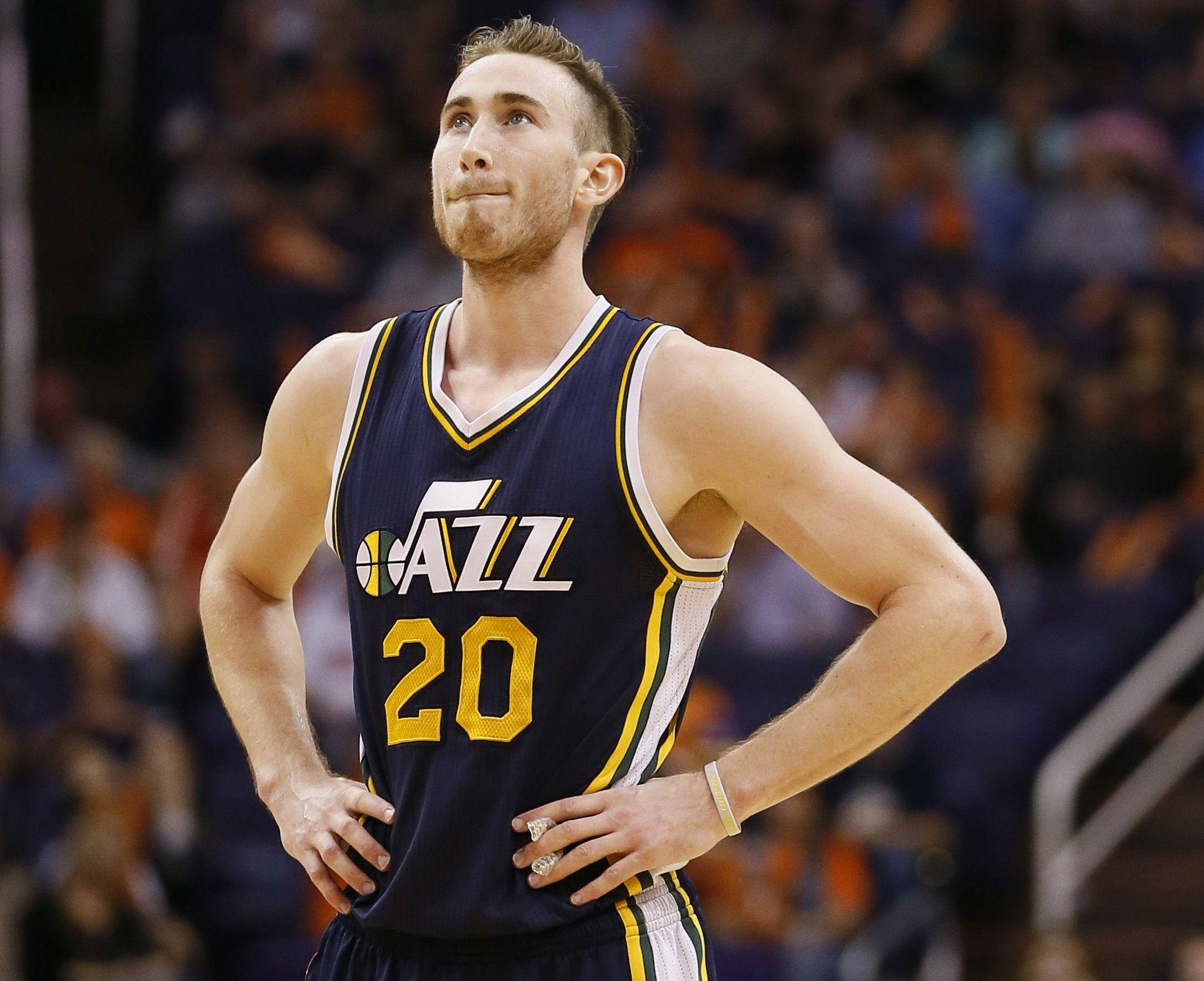 gordon hayward 桌布 壁紙 — 一位身穿海軍藍爵士隊球衣、背號20的籃球運動員在比賽中自信地雙手叉腰站立。
