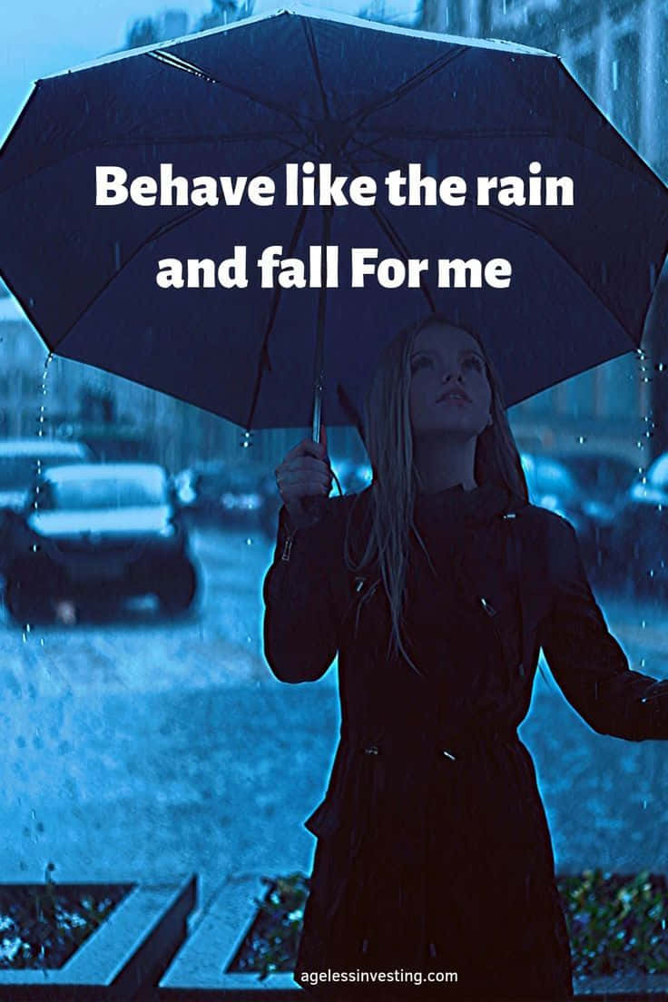 桌布 壁紙 — 一位身穿深色外套的女性撐著黑色雨傘，在藍色調的城市街景中，雨水在她周圍落下。
