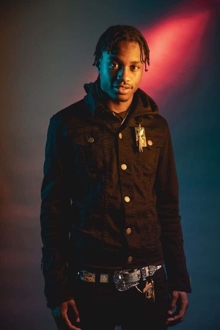 Rappers 桌布 壁紙 — 一位身穿深色牛仔外套的年輕男子，在戲劇性的紅藍色攝影棚燈光下，表情嚴肅地站立。
