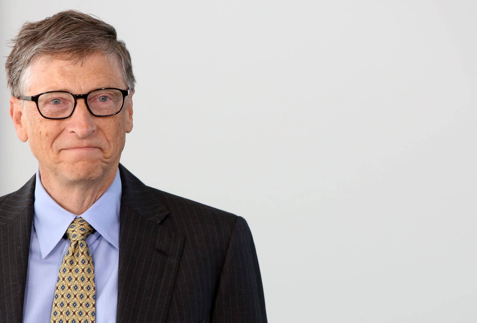 一位身穿西裝和眼鏡、表情嚴肅的男子。 — Microsoft 壁紙