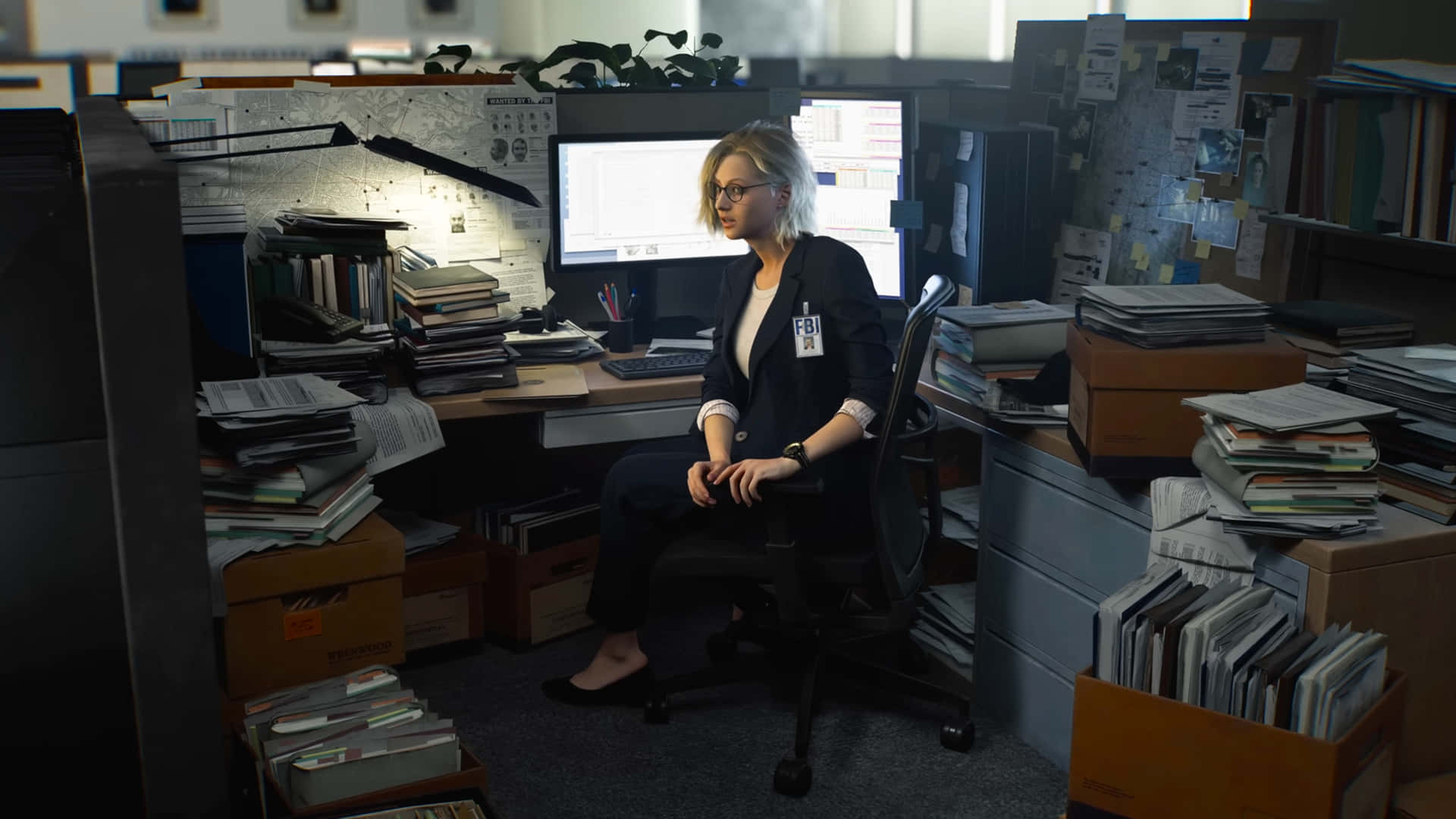 Grace Ashcroft - Resident Evil Requiem 壁紙 — 一位身穿深色西裝外套的女性坐在雜亂的辦公桌前，周圍堆滿了文件夾和發光的電腦顯示器。