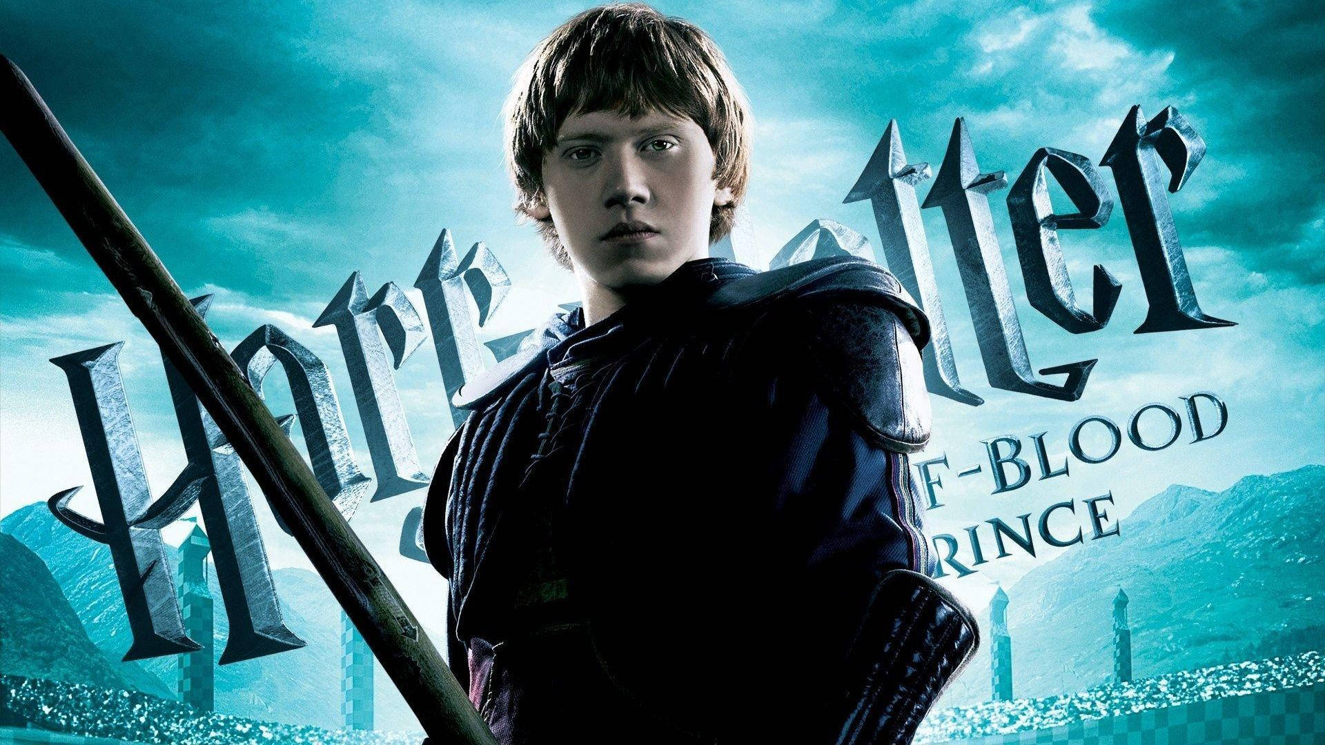 Ron Weasley 桌布 壁紙 — 一位身穿深色長袍的年輕巫師，手持魔杖，背景是青綠色的天空、城堡塔樓和電影標題文字。