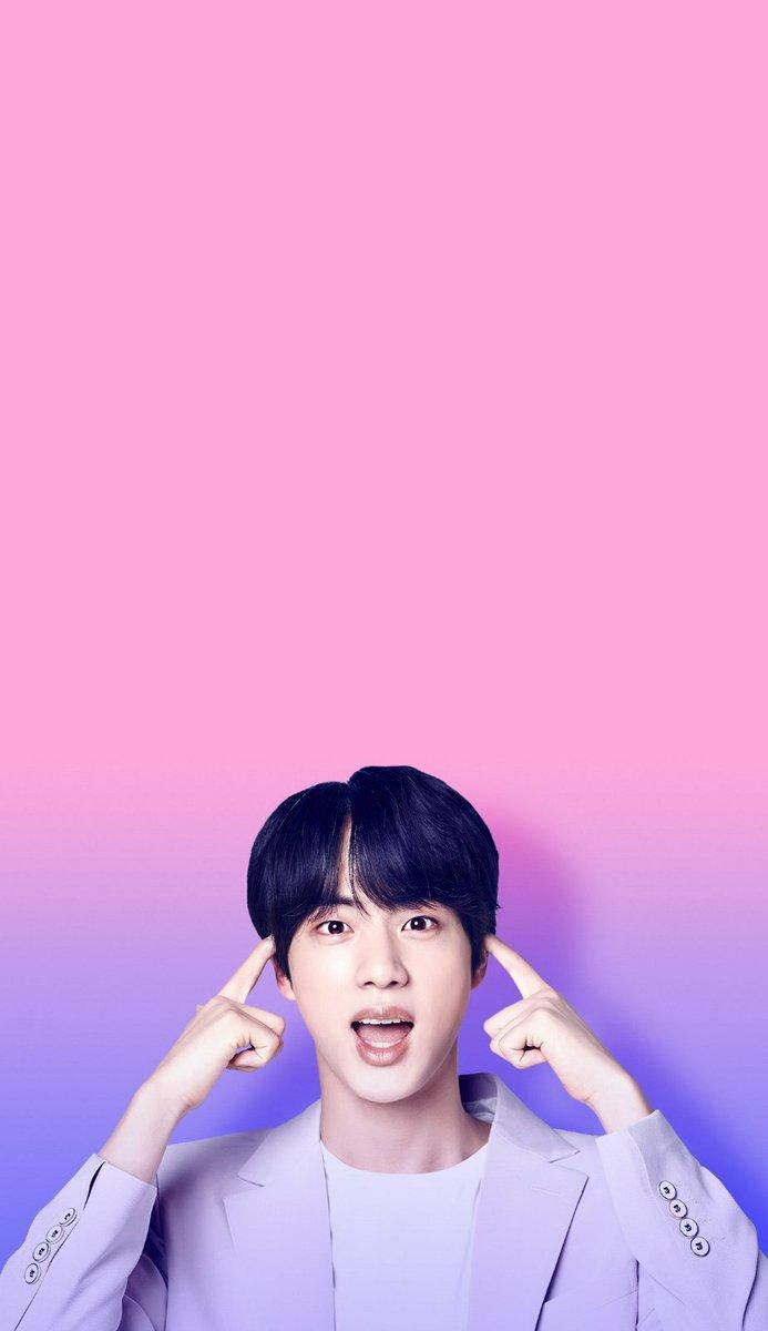Jin 桌布 壁紙 — 一位身穿淺色西裝的年輕男子在充滿活力的粉紅和紫色漸變背景前指著太陽穴。