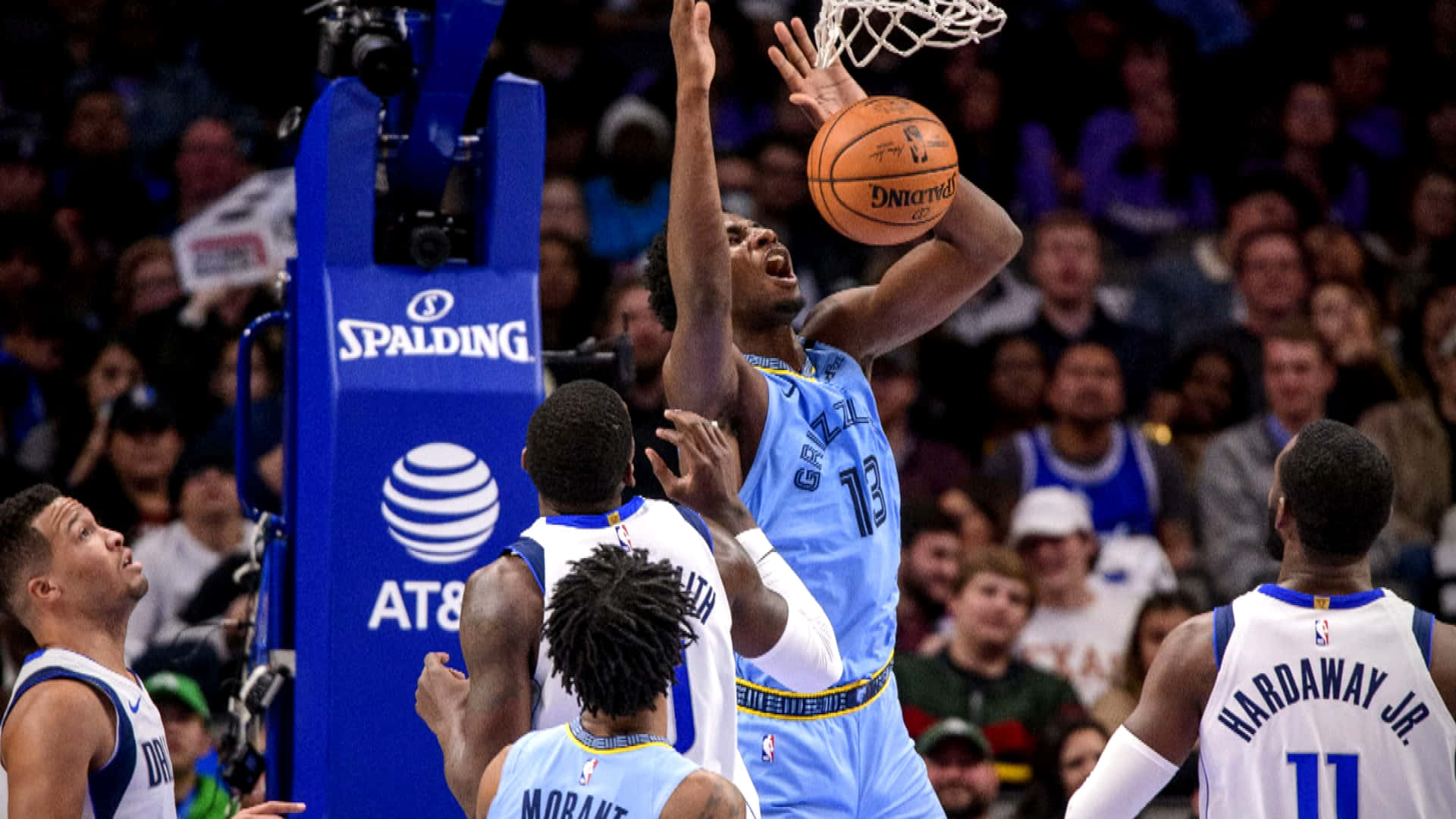 NBA Players 桌布 壁紙 — 一位身穿淺藍色球衣的籃球運動員在防守球員從下方觀看時灌籃。