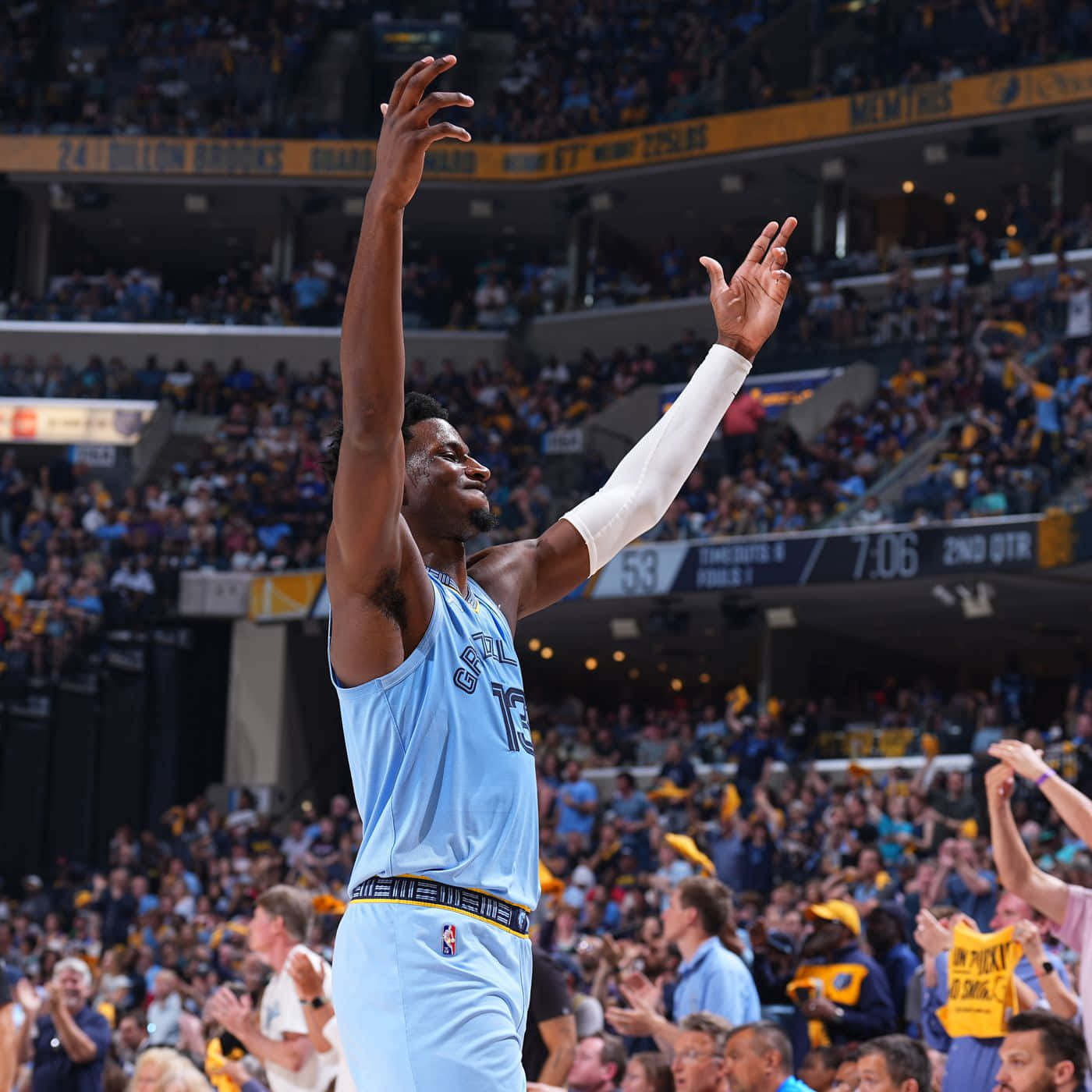 NBA 桌布 壁紙 — 一位身穿淺藍色球衣的籃球運動員在座無虛席的場館中高舉雙臂，慶祝勝利，球迷們歡呼雀躍。
