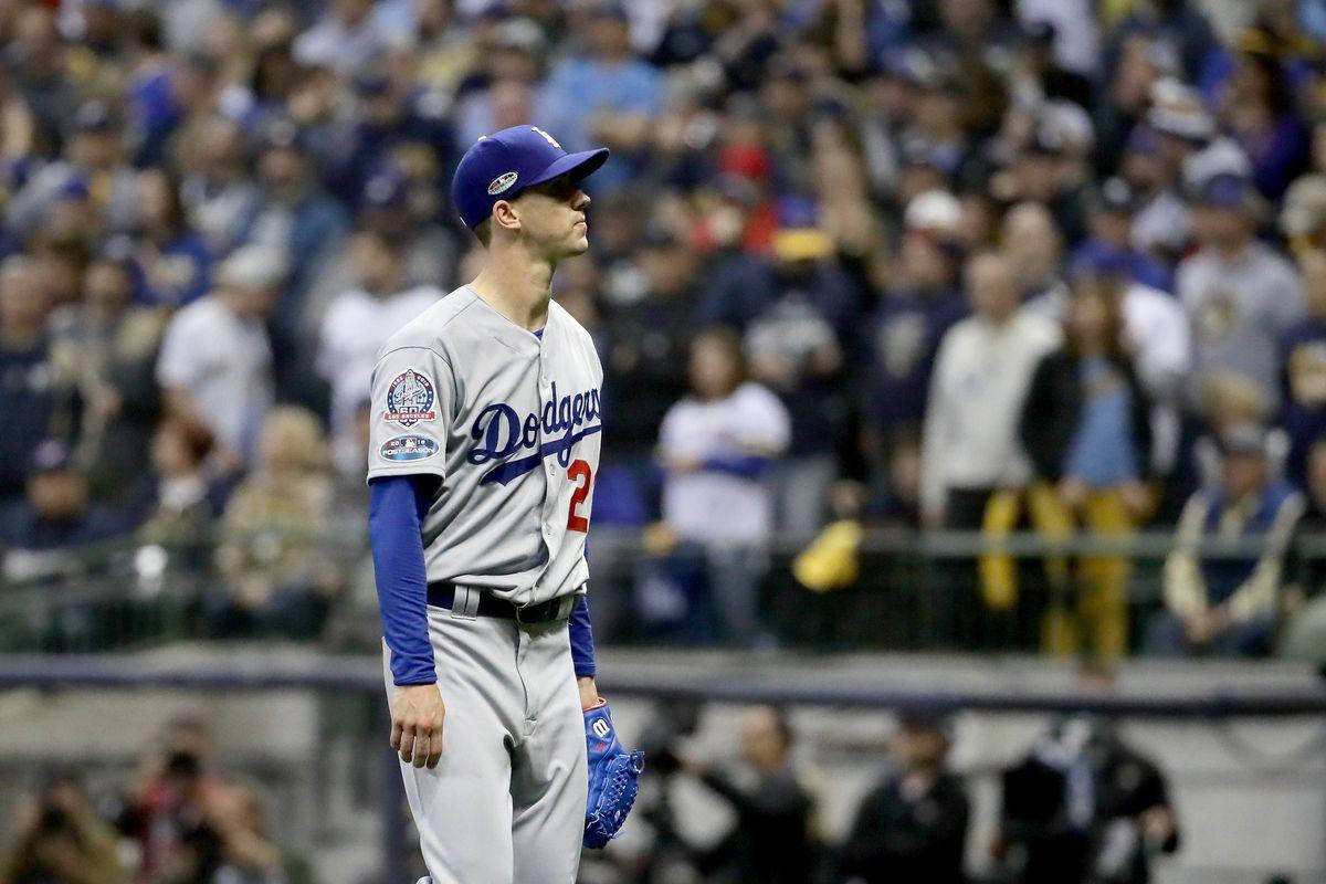 walker buehler 桌布 壁紙 — 一位身穿灰色球衣的洛杉磯道奇棒球選手莊嚴地站在球場上，背景是人群。