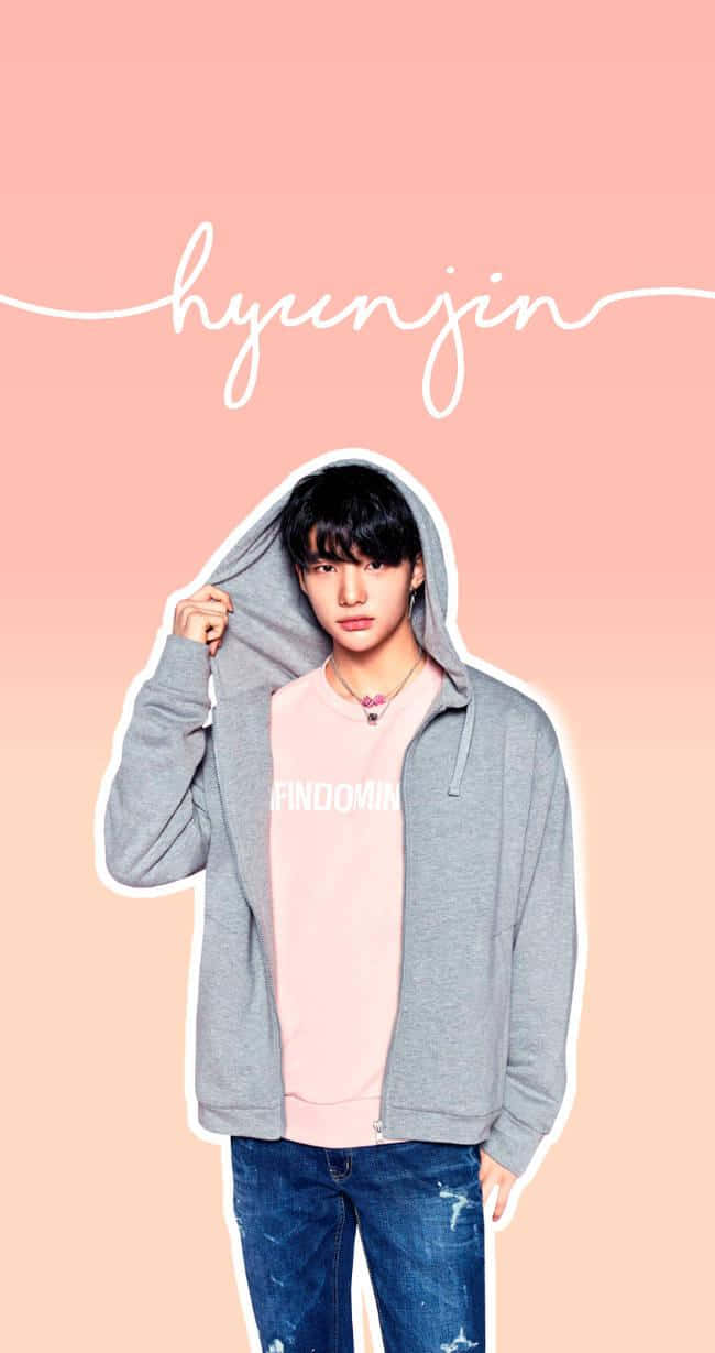 hyunjin 桌布 壁紙 — 一位身穿灰色連帽衫和粉紅色襯衫的年輕男子在柔和的粉紅色漸變背景前擺姿勢，上方寫有他的名字。