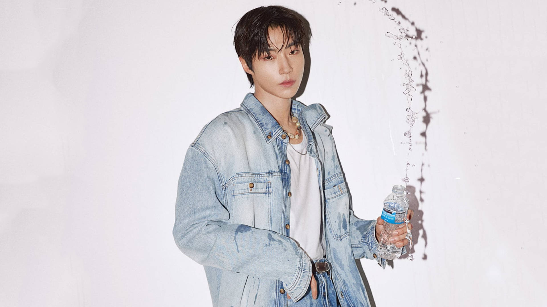 Hwang In Yeop 桌布 壁紙 — 一位身穿牛仔外套的年輕男子手持水瓶，液體在他身後戲劇性地弧線飛濺，背景為純白色。