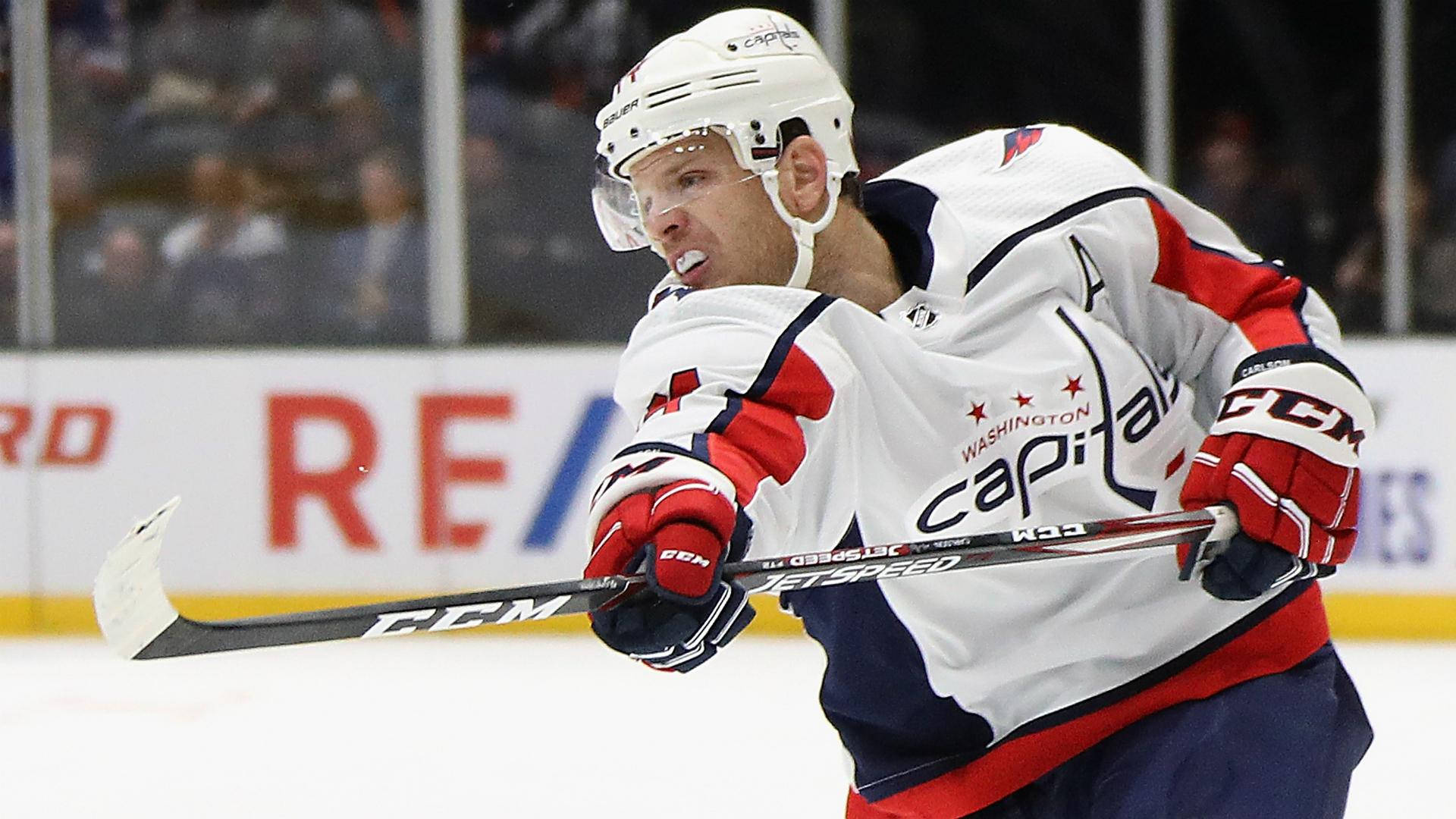 sport 桌布 壁紙 — 一位身穿白、紅、藍色球衣的華盛頓首都隊冰球球員，在冰上比賽中全神貫注。