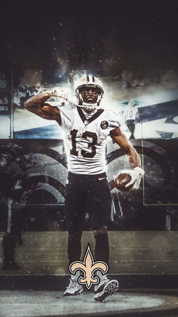 NFL Saints 桌布 壁紙 — 一位身穿白色13號球衣的紐奧良聖徒隊美式足球員在球場燈光下高舉足球勝利慶祝。