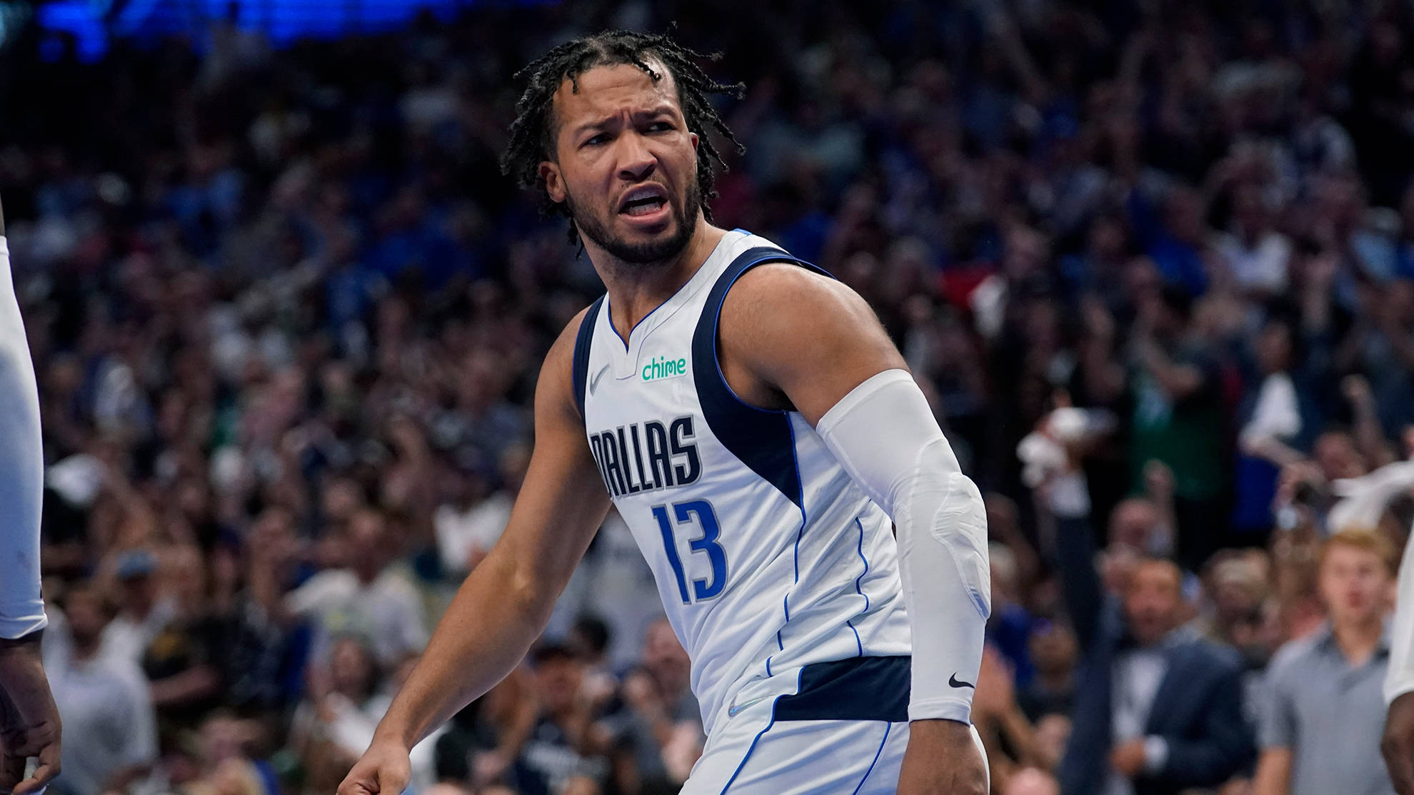 NBA 桌布 壁紙 — 一位身穿白色13號球衣的達拉斯獨行俠籃球運動員在比賽中激烈大喊，背景是模糊的人群。