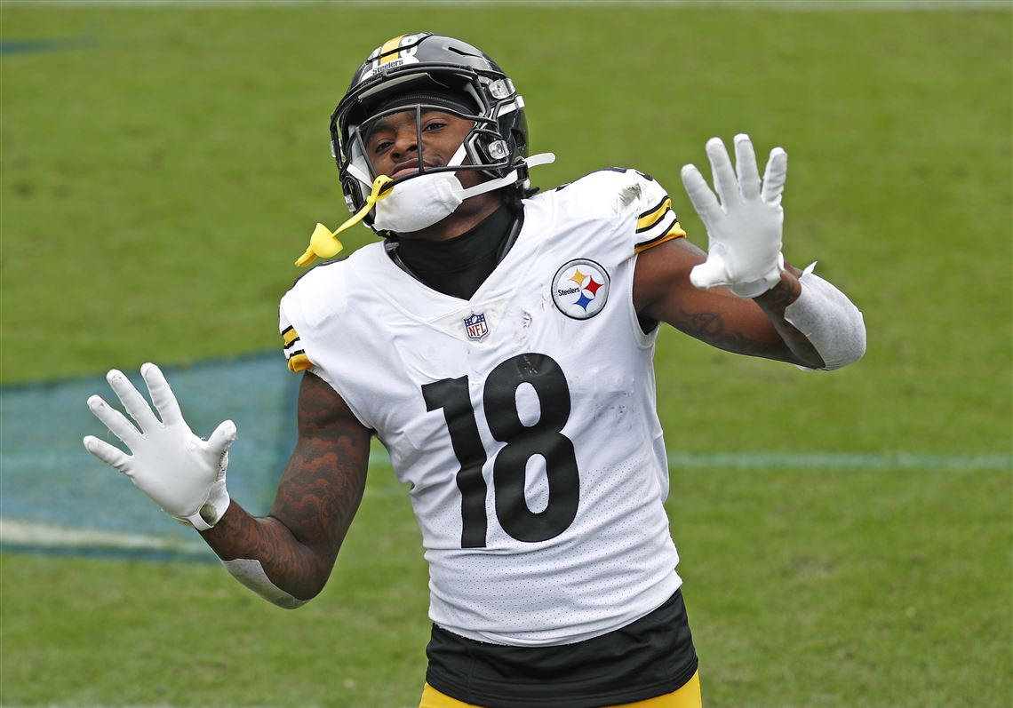 Diontae Johnson 桌布 壁紙 — 一位身穿白色18號球衣的匹茲堡鋼人隊美式足球員在綠色球場上高舉雙臂慶祝。