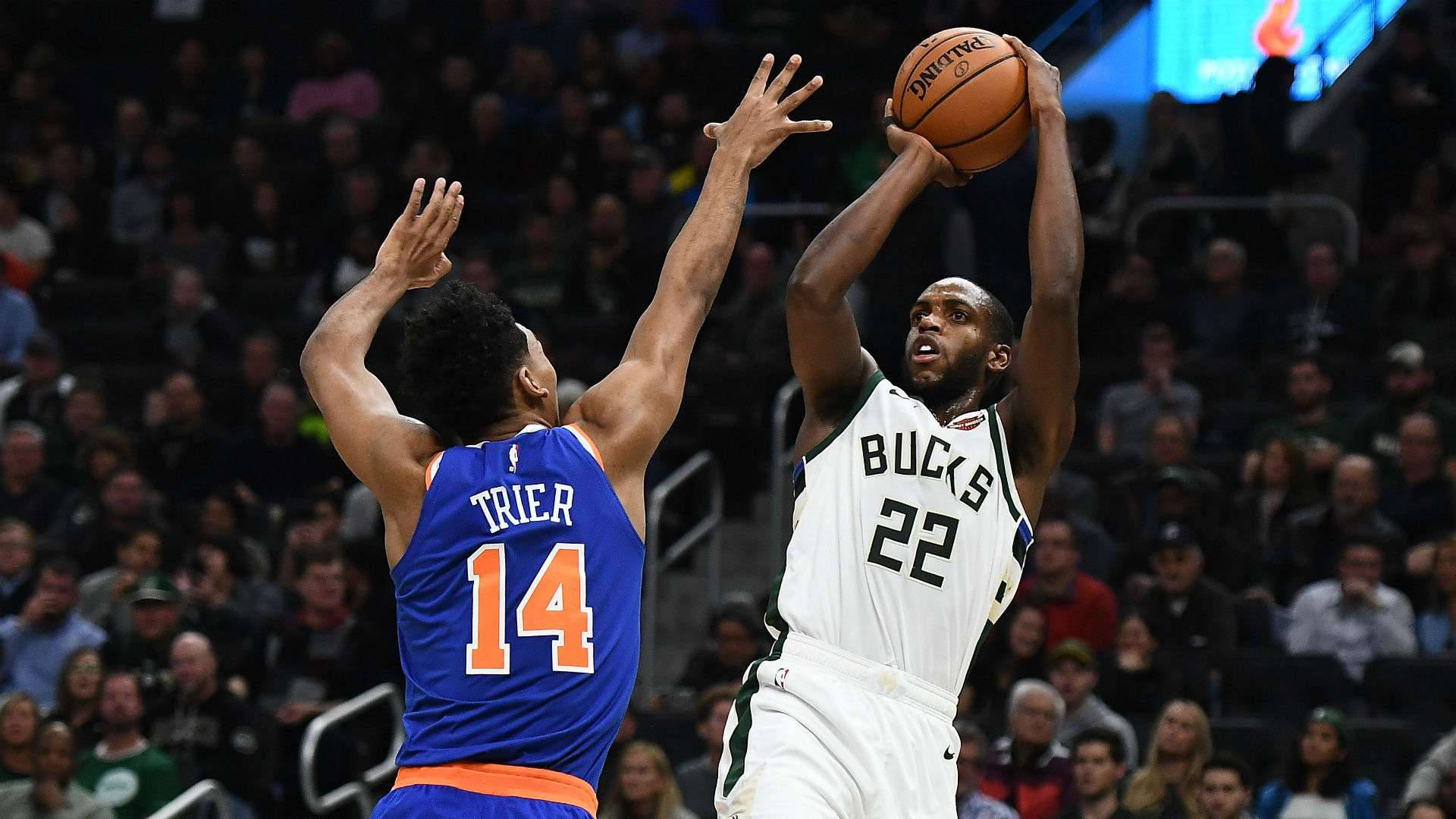 Khris Middleton 桌布 壁紙 — 一位身穿白色22號球衣的密爾瓦基公鹿球員跳起投籃，而一位身穿藍色14號球衣的紐約尼克防守球員跳起封阻。