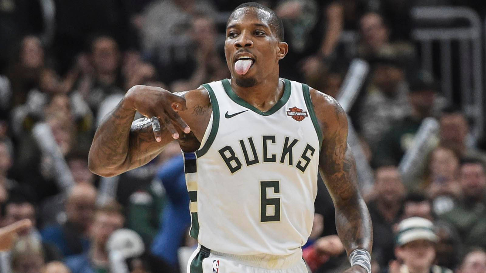 eric bledsoe 桌布 壁紙 — 一位身穿白色6號球衣的密爾瓦基公鹿籃球運動員在比賽中伸出舌頭並指向觀眾，背景是模糊的人群。