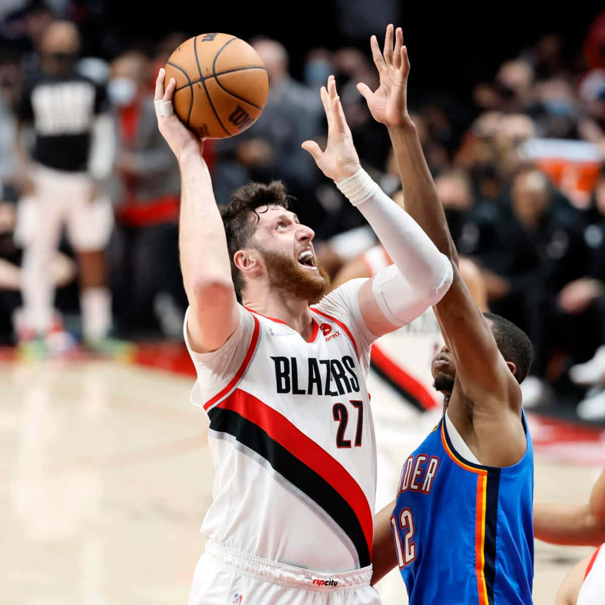 籃球 桌布 壁紙 — 一位身穿白色Blazers球衣的籃球運動員跳投，而一位身穿藍色球衣的防守球員伸手阻擋。