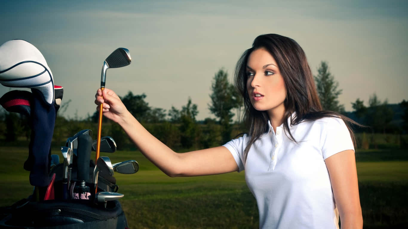 1366x768 Golf Course 桌布 壁紙 — 一位身穿白色Polo衫的女性在柔和的天空下，於草地上從球袋中挑選高爾夫球桿。
