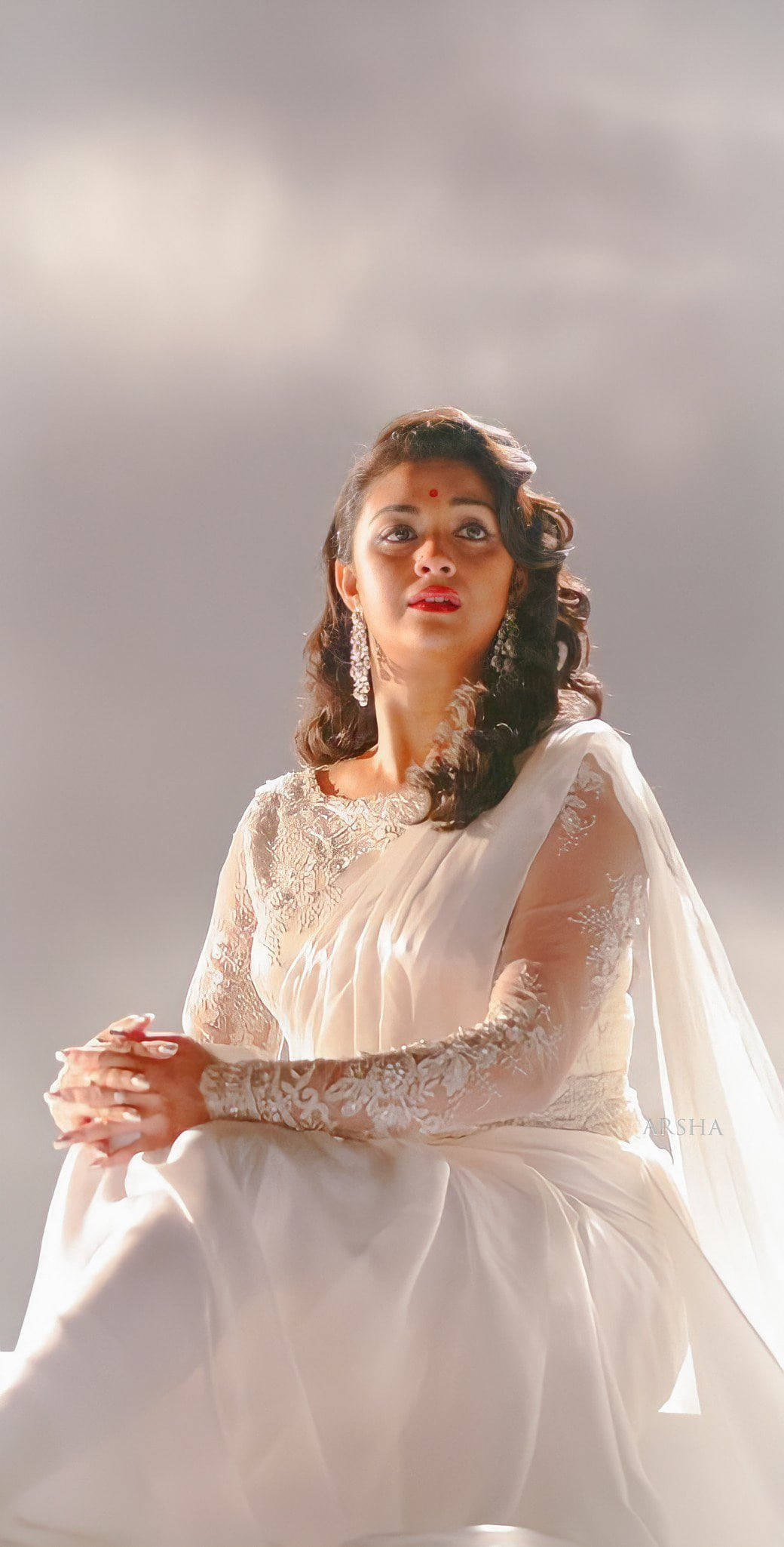 telugu 桌布 壁紙 — 一位身穿白色刺繡紗麗的女性，在柔和的灰色背景和戲劇性燈光下優雅地坐著。