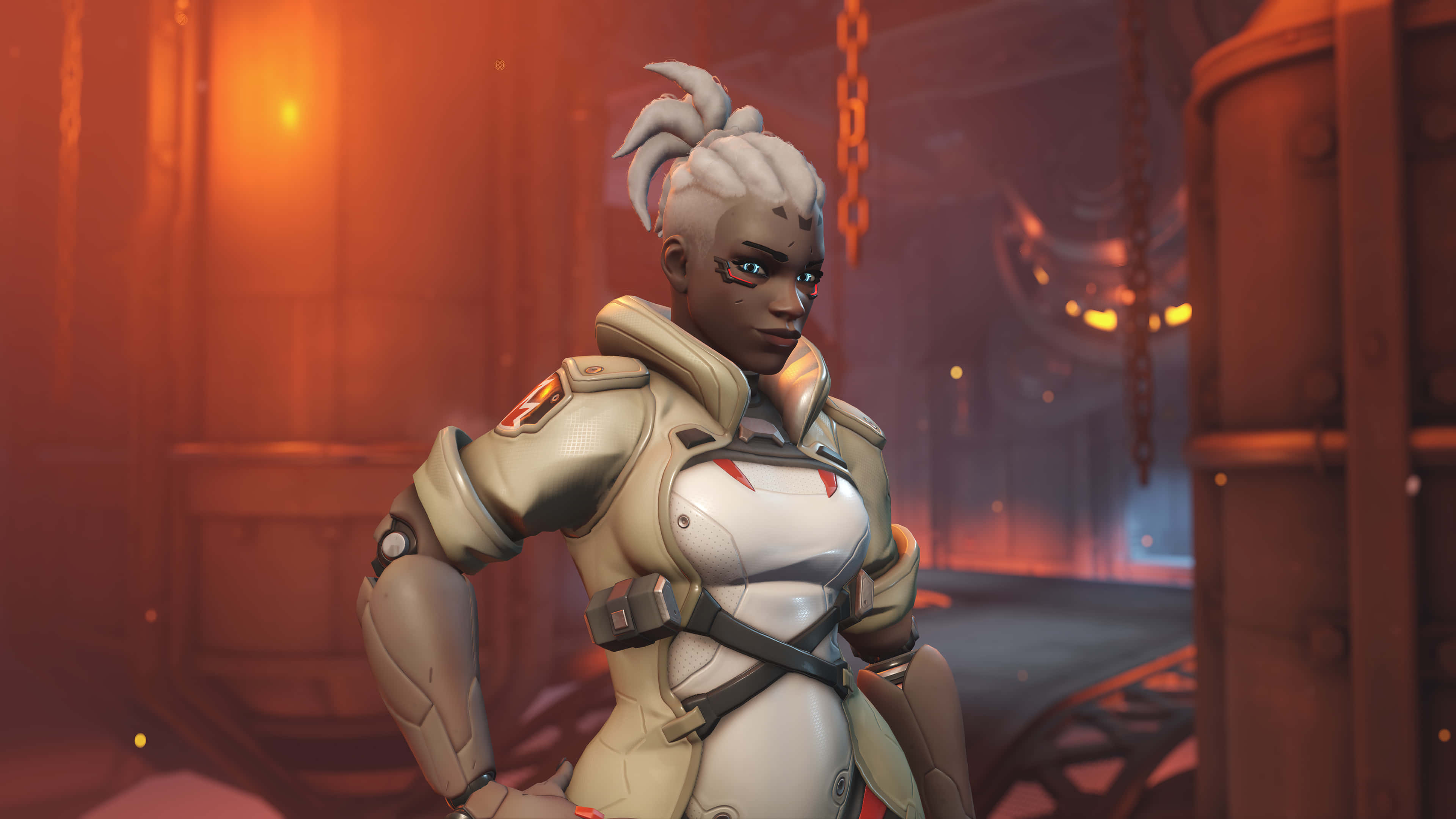 Overwatch Heroes 桌布 壁紙 — 一位身穿白色和灰色戰術裝備的女性《鬥陣特攻》英雄，自信地站在光線昏暗、帶有溫暖橙色照明的工業環境中。