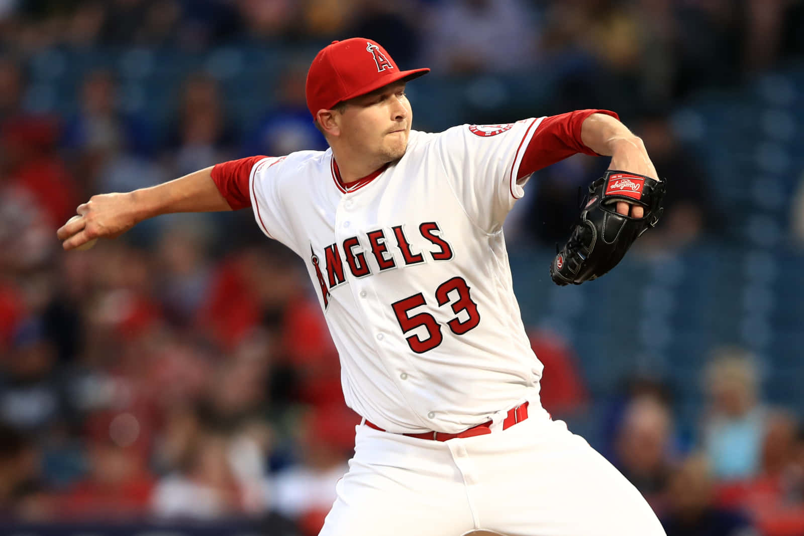 MLB Players 桌布 壁紙 — 一位身穿白色和紅色天使隊球衣的棒球投手，在夜間比賽中專注地投球。