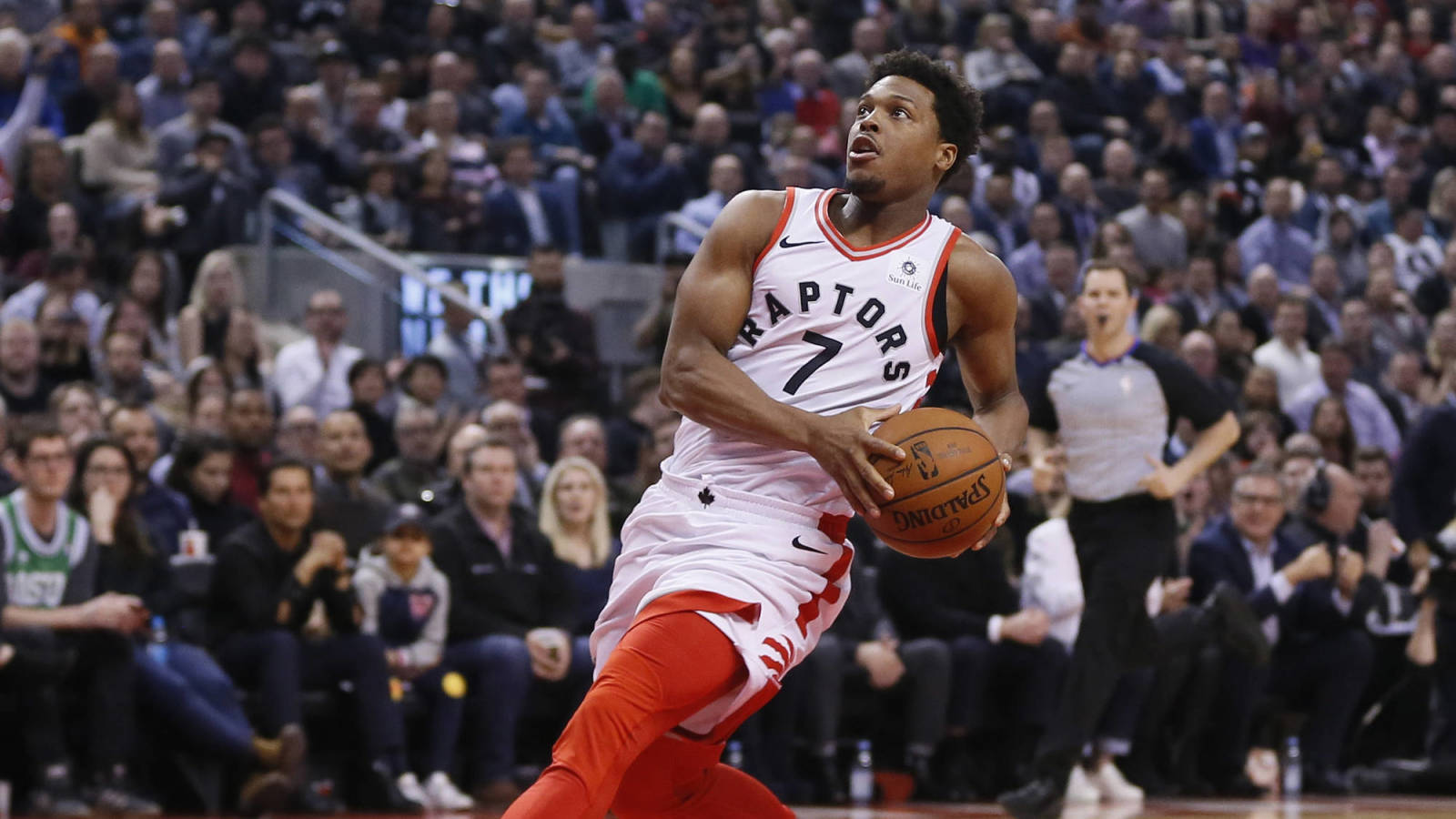 Lowry 桌布 壁紙 — 一位身穿白色和紅色球衣的多倫多暴龍籃球運動員在比賽中專注地運球，面對座無虛席的場館觀眾。