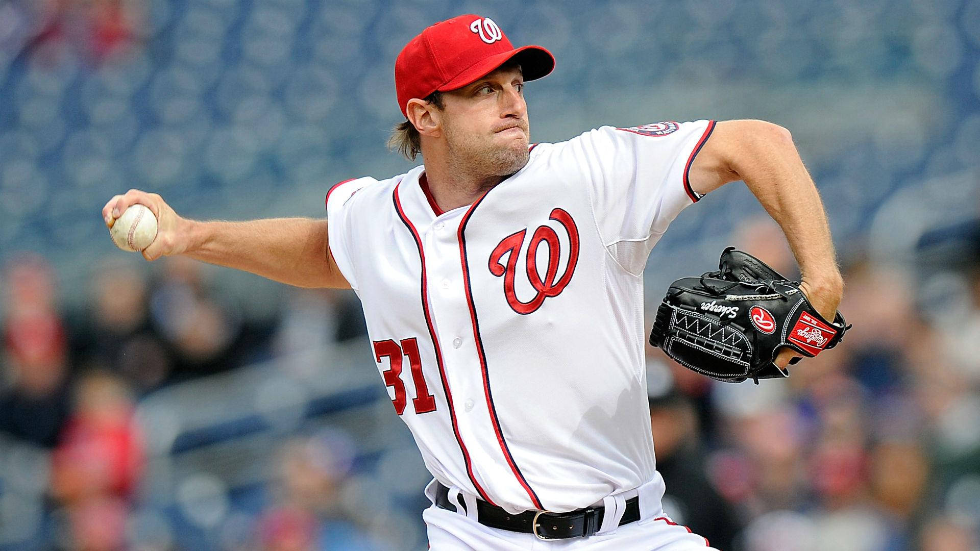 Max Scherzer 桌布 壁紙 — 一位身穿白色和紅色球衣的棒球投手在陽光明媚的日子於球場上投球，背景有模糊的觀眾。