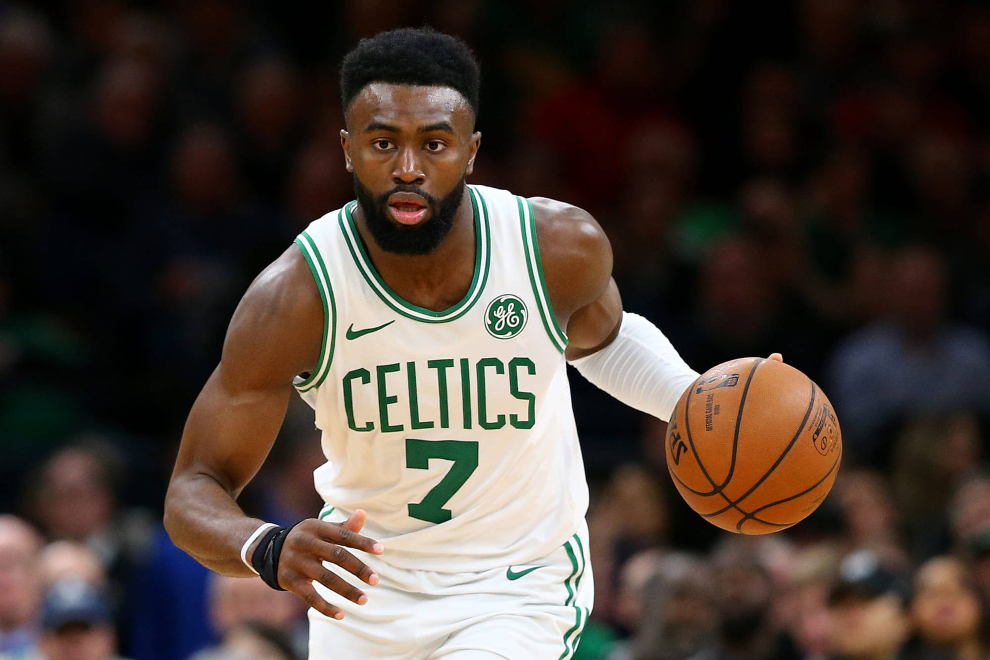 Jaylen Brown 桌布 壁紙 — 一位身穿白色和綠色球衣的波士頓塞爾提克籃球運動員在比賽中專注地運球。