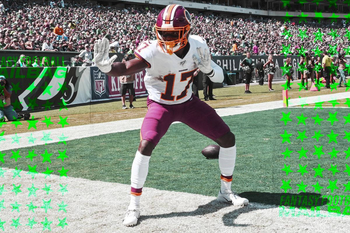 Football Players 桌布 壁紙 — 一位身穿白色和酒紅色球衣的華盛頓美式足球隊球員在陽光明媚的球場上慶祝，身後有歡呼的人群。