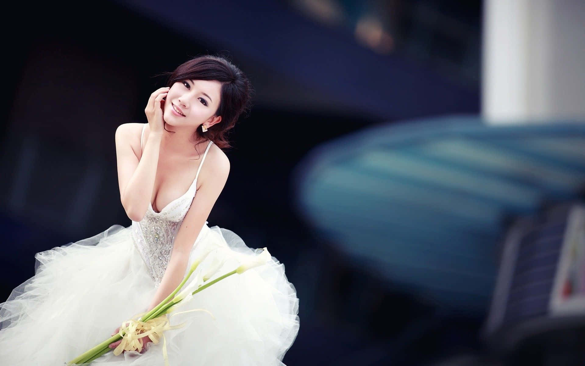 Bridal 桌布 壁紙 — 一位身穿白色婚紗的女性，在模糊的深色背景下，手持一束白色馬蹄蓮，溫柔地微笑。