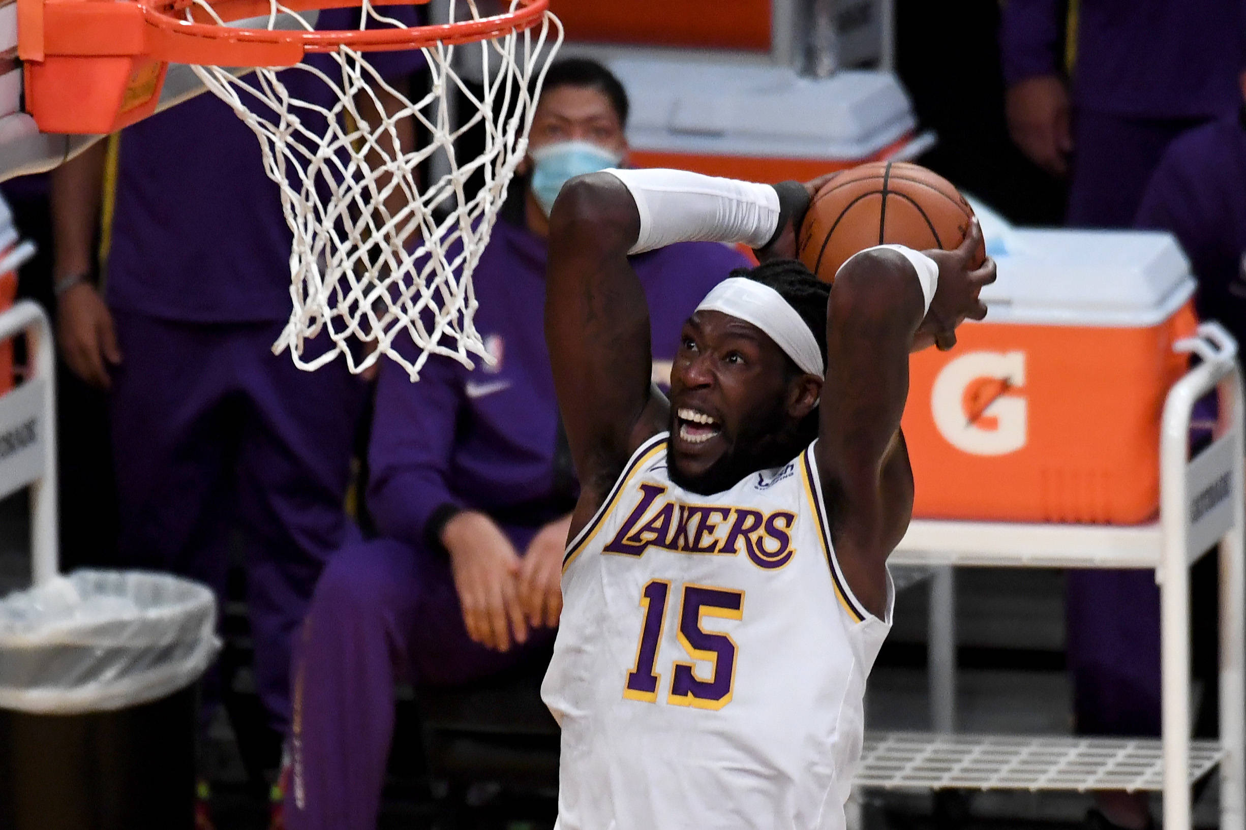 montrezl harrell 桌布 壁紙 — 一位身穿白色湖人球衣的籃球運動員在明亮的場館燈光下，專注地灌籃。