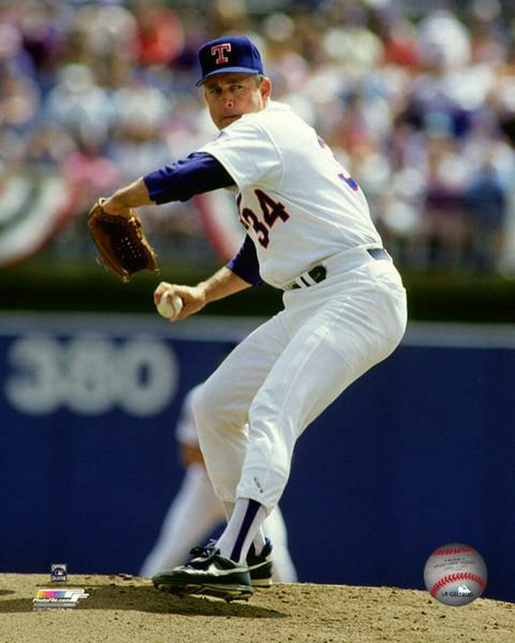 Nolan Ryan 桌布 壁紙 — 一位身穿白色球衣、背號34的棒球投手，在陽光明媚的投手丘上準備投球，背景是模糊的人群。