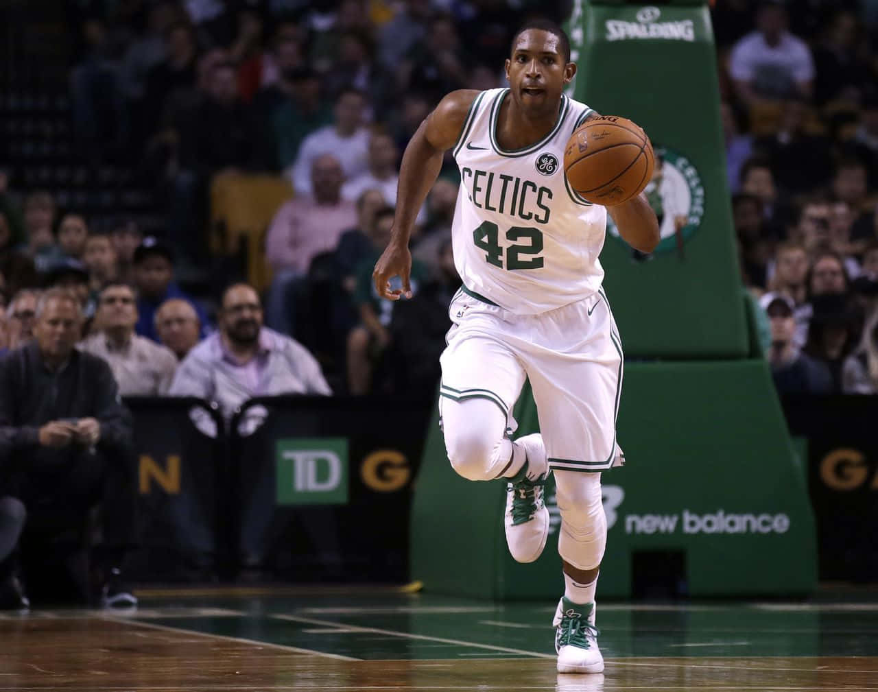Al Horford 桌布 壁紙 — 一位身穿白色球衣、背號42的波士頓塞爾提克籃球運動員，在滿場觀眾的背景下，於一場激烈的比賽中運球。