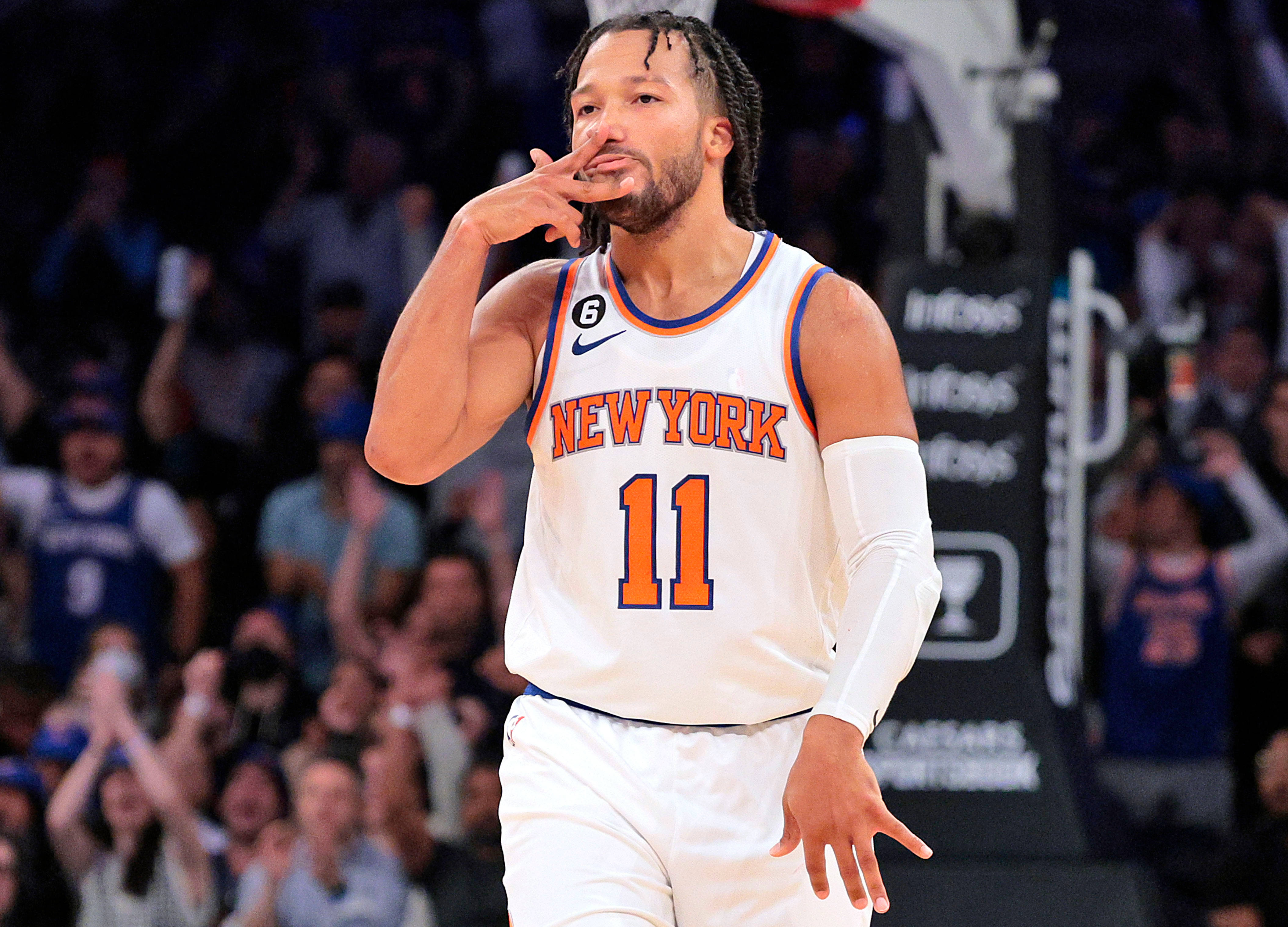 NBA 桌布 壁紙 — 一位身穿白色球衣11號的紐約尼克籃球球員在比賽中於球場上用手勢示意，背後有模糊的人群。