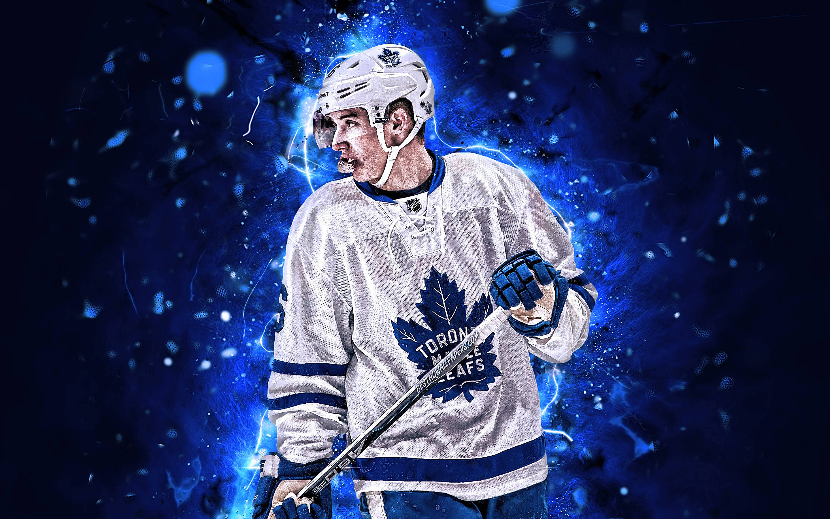 Leafs 桌布 壁紙 — 一位身穿白色球衣的多倫多楓葉隊冰球運動員，在充滿活力的藍色電能爆發背景前動態站立。
