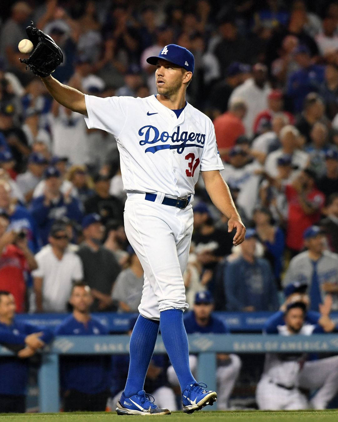 Athletic 桌布 壁紙 — 一位身穿白色球衣的洛杉磯道奇棒球選手在夜間比賽中，在球場燈光下投擲棒球，身後是模糊的人群。
