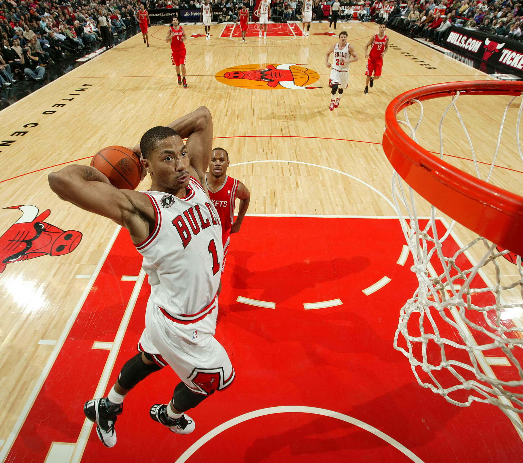 derrick rose 桌布 壁紙 — 一位身穿白色球衣的芝加哥公牛隊球員強力灌籃，對手在場上觀看。