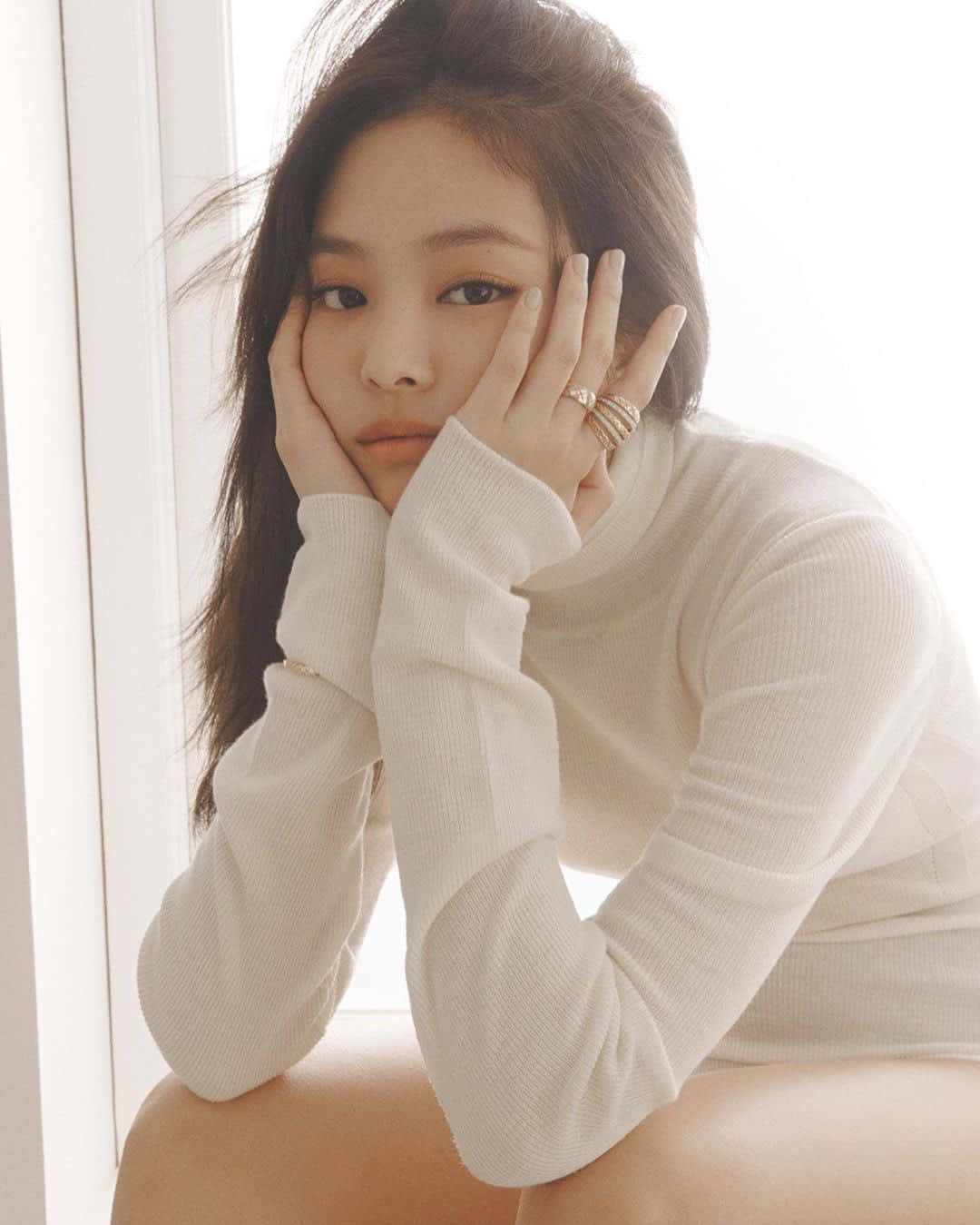 BLACKPINK 桌布 壁紙 — 一位身穿白色羅紋毛衣的女性坐在明亮的窗邊，雙手托腮，目光沉思。