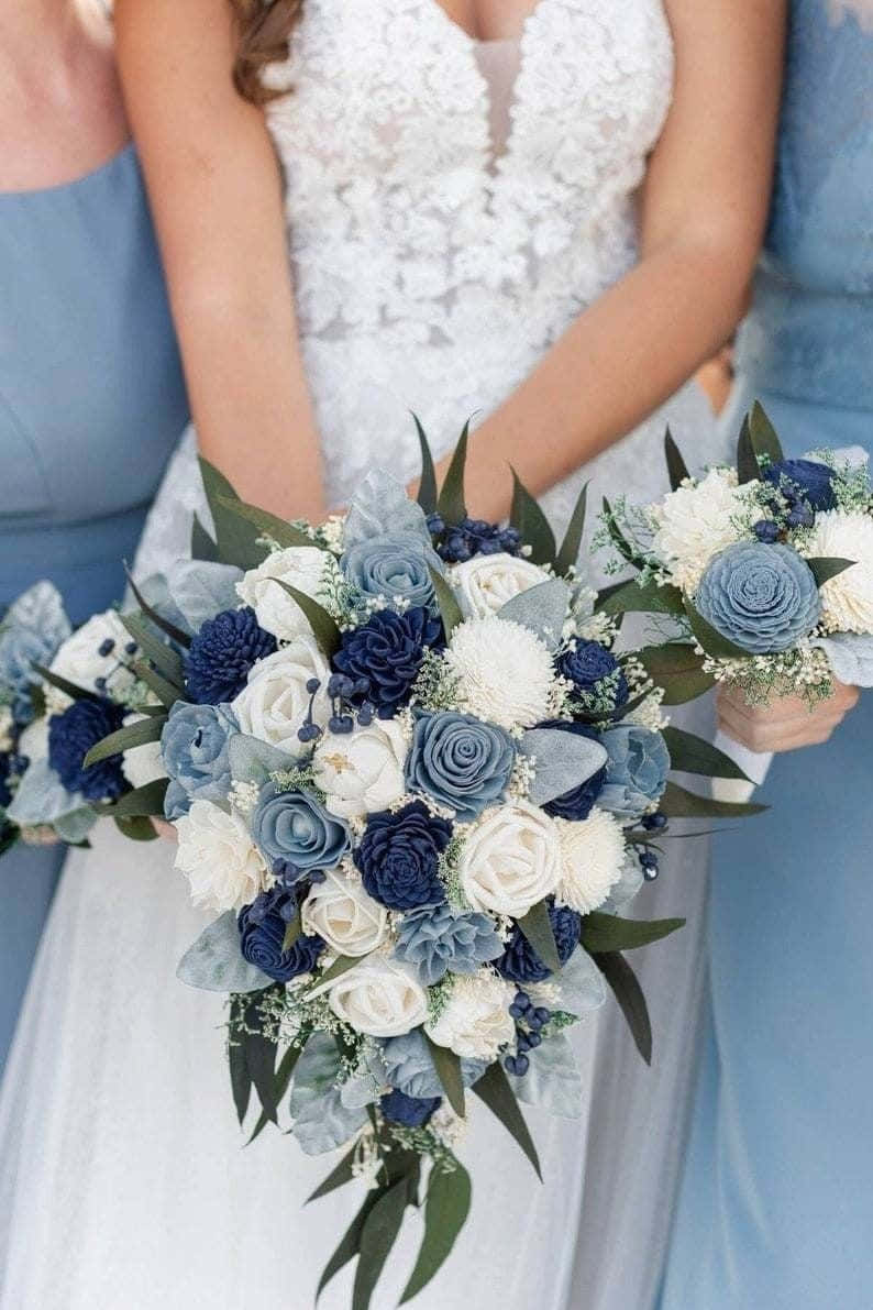 Rose Flower 桌布 壁紙 — 一位身穿白色蕾絲婚紗的新娘手持一束由海軍藍和白色玫瑰搭配綠葉組成的瀑布式花束。