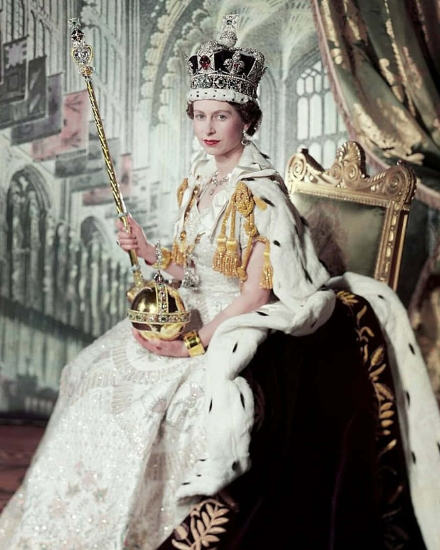 女王 桌布 壁紙 — 一位身穿白色貂皮長袍、頭戴珠寶王冠的威嚴女性坐在金色王座上，手持權杖和寶球。