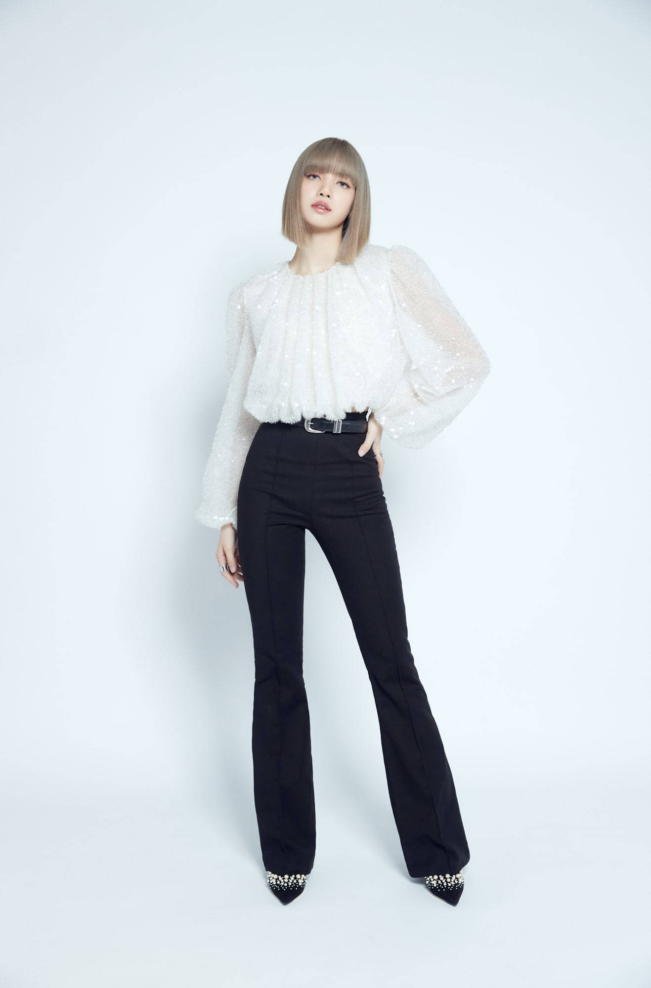 Lalisa 桌布 壁紙 — 一位身穿白色質感襯衫和黑色喇叭褲的女性在純白背景前自信地擺姿勢。