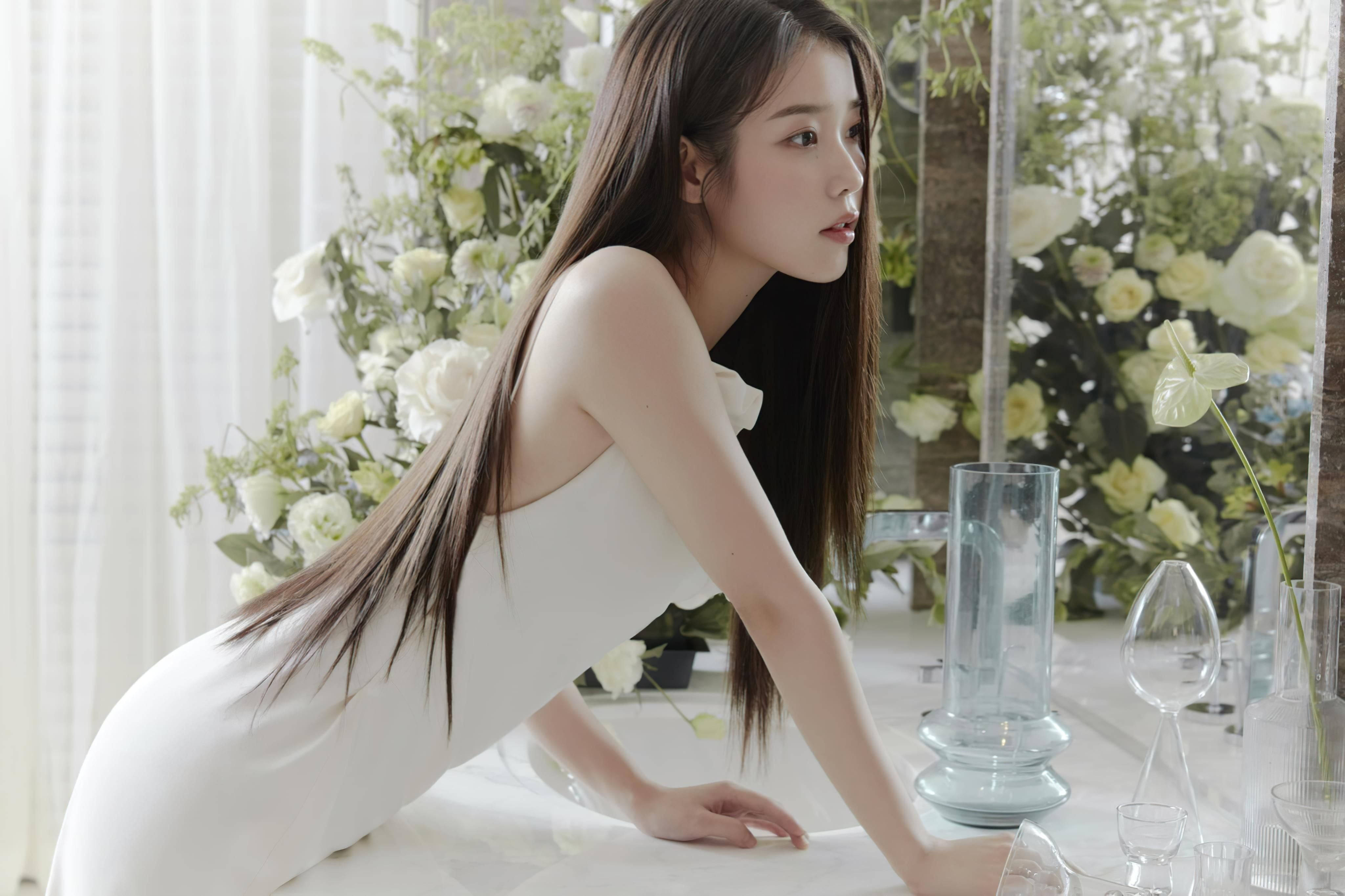 女孩 桌布 壁紙 — 一位身穿白色連衣裙的女性優雅地俯身在一張擺滿茂盛白色花卉和玻璃器皿的桌子上。