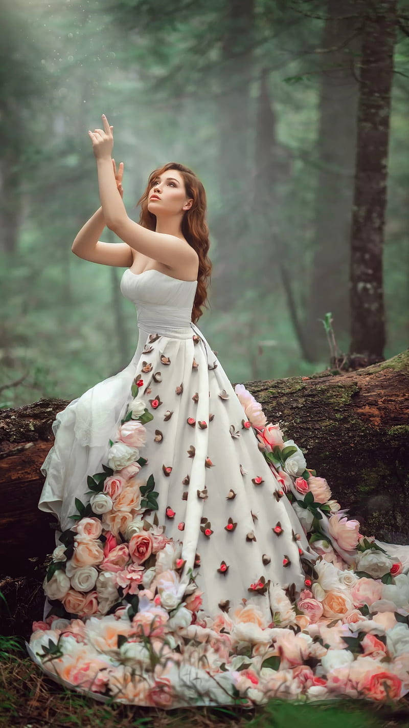 Bridal 桌布 壁紙 — 一位身穿白色長袍、飾有粉紅和蜜桃色玫瑰的女性，優雅地站在迷霧森林中，向上伸手，彷彿在召喚魔法。