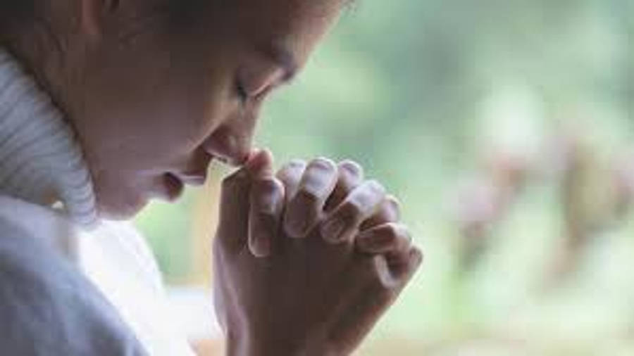 Praying Hands 桌布 壁紙 — 一位身穿白色高領毛衣的人，在柔和自然光線的窗邊合十祈禱。